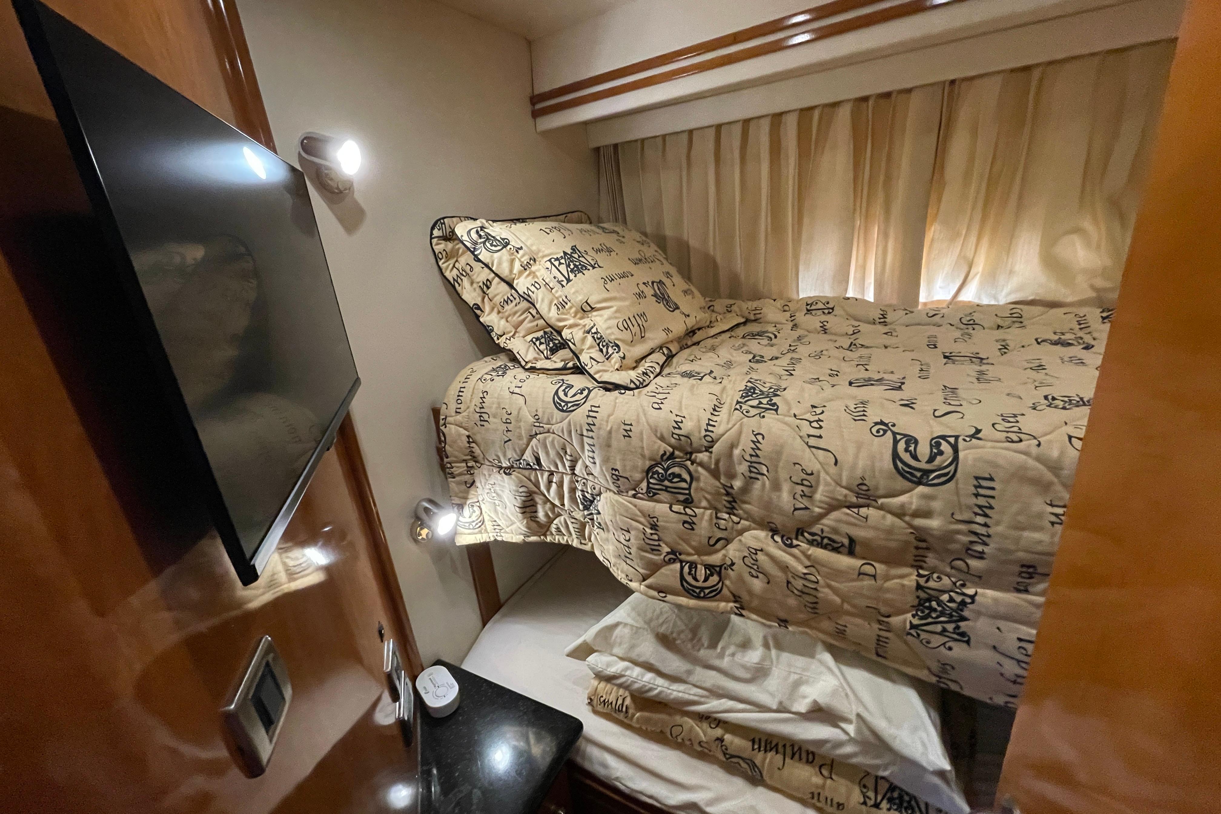 Cozy cabin interior of 2002 Carver 570 Voyager Pilothouse with bunk bed and TV.