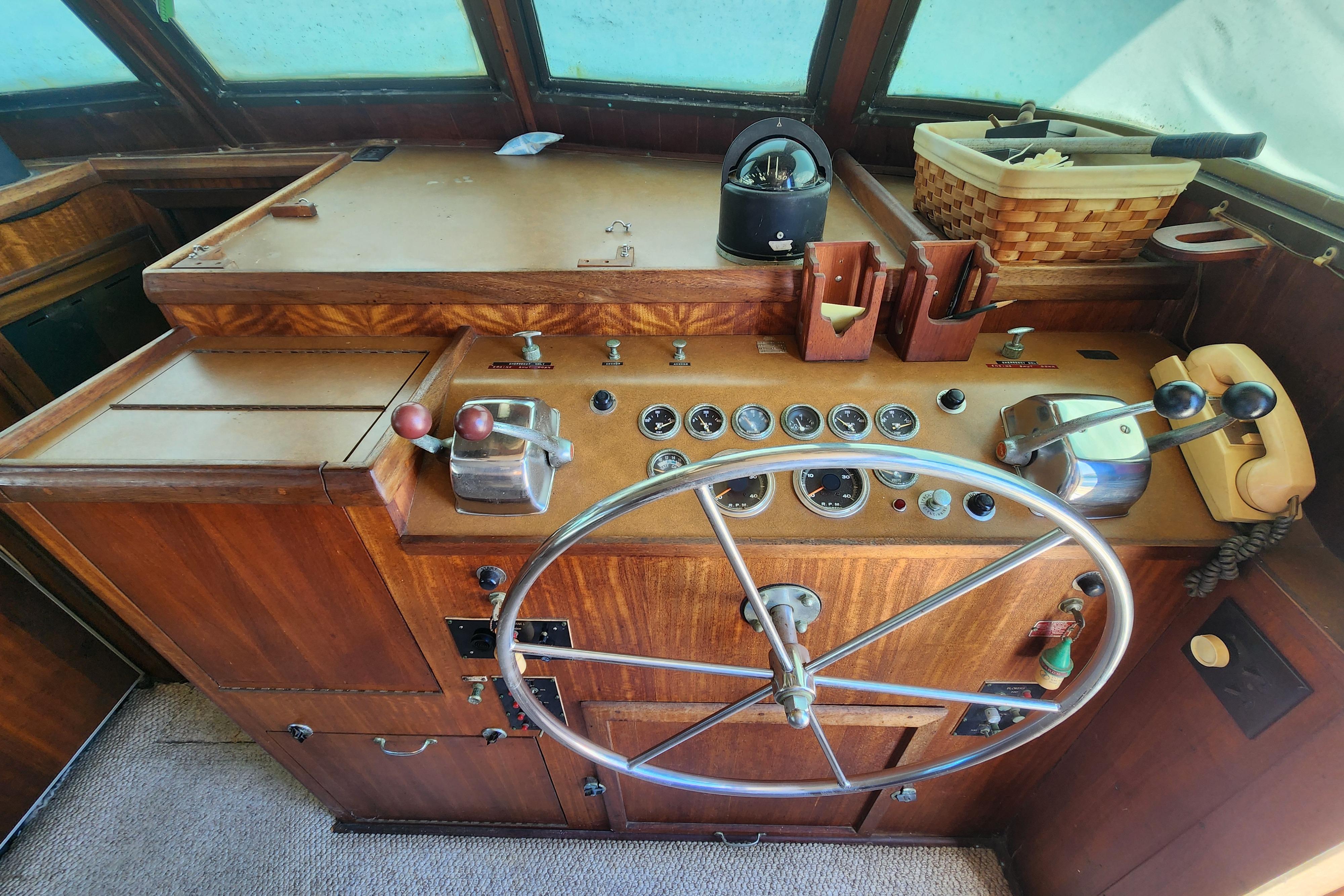 1976 Hatterus 42 Long Range Cruiser helm with vintage controls and steering wheel.