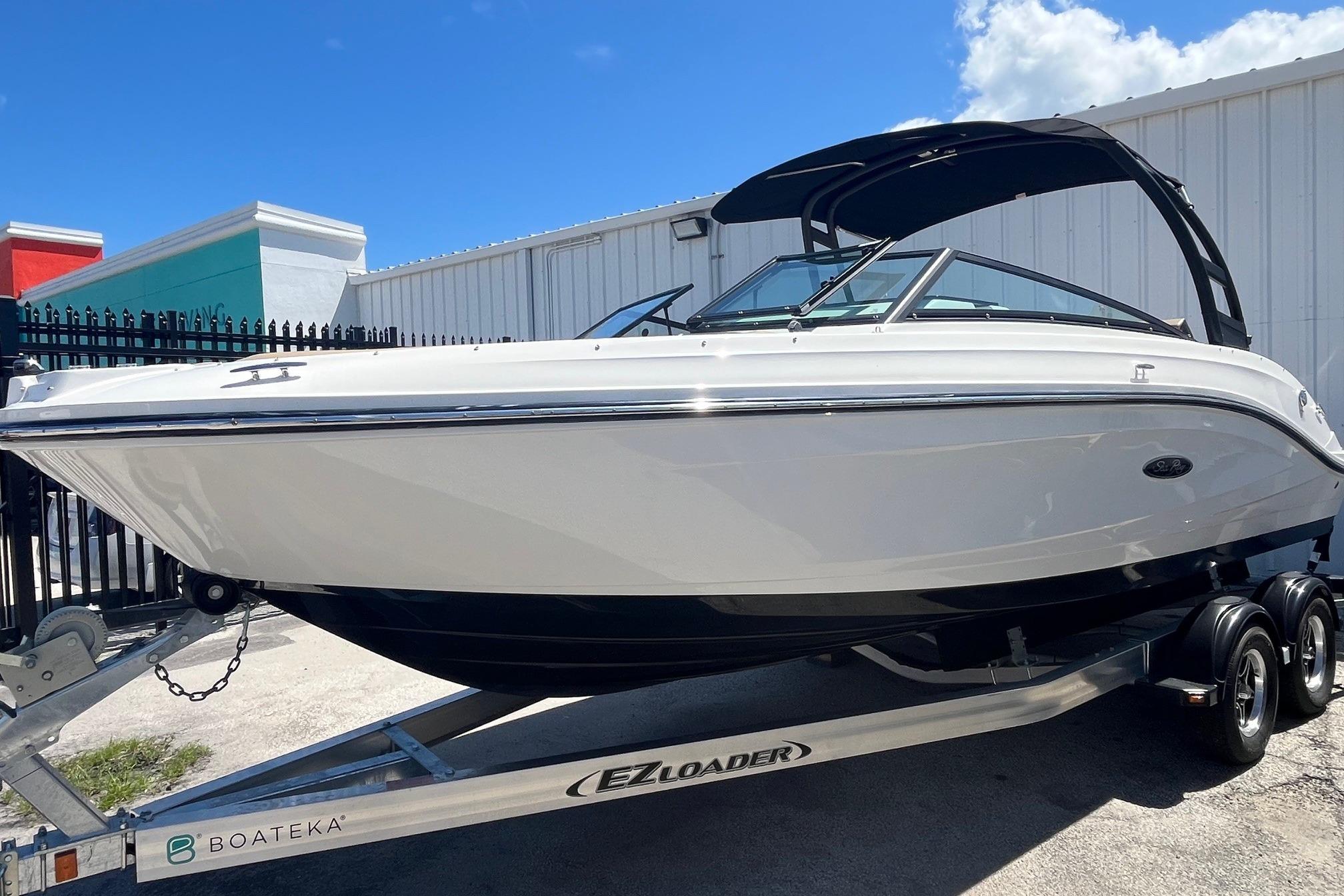 2024 Sea Ray SPX 230 boat on trailer, displayed outdoors under clear blue sky.