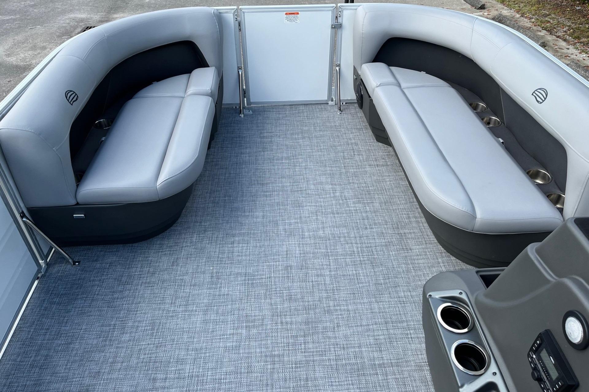 2026 Sun Tracker Party Barge 16 DLX interior with gray seating and cup holders.