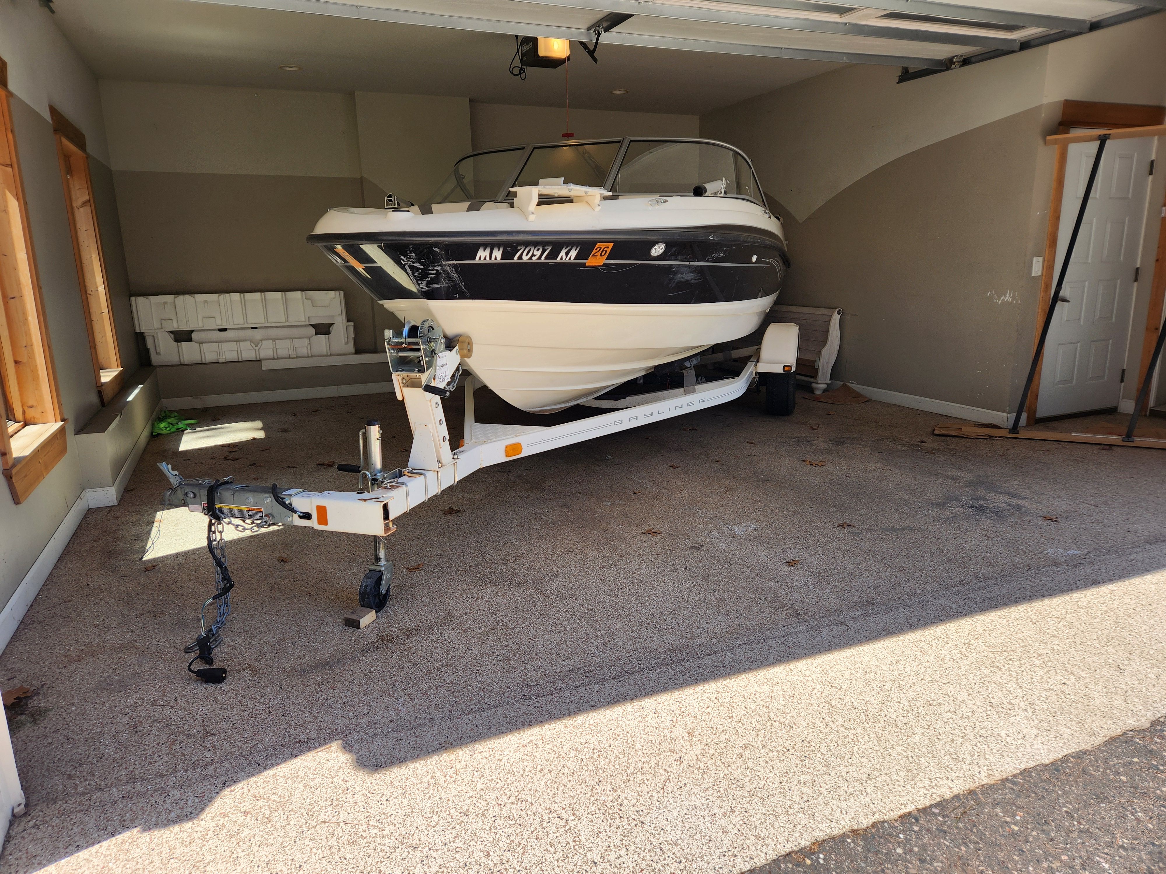 A 2009 Bayliner 194SF boat on a trailer inside a garage.