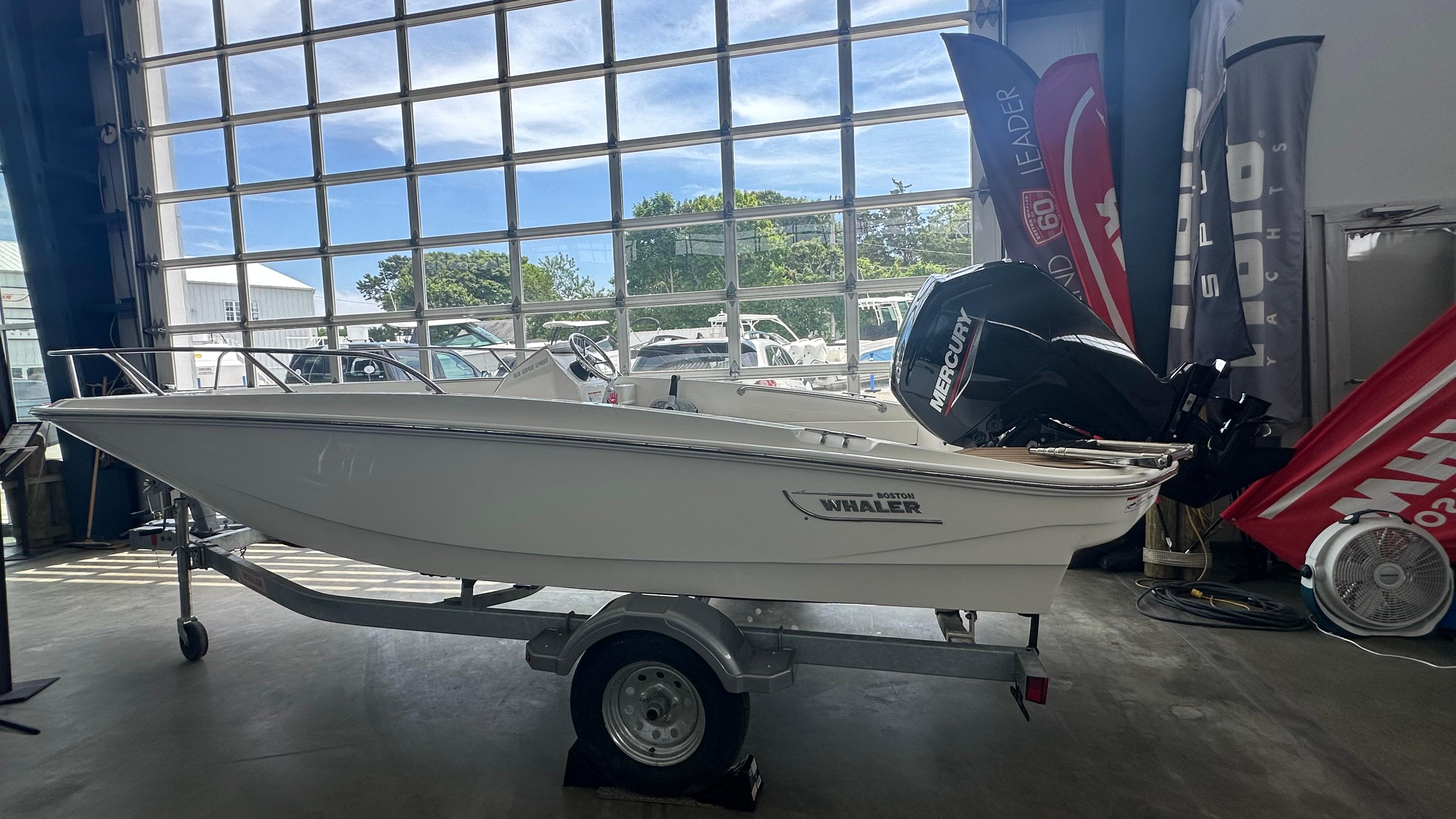 2025 Boston Whaler 160 Super Sport boat on trailer in showroom.