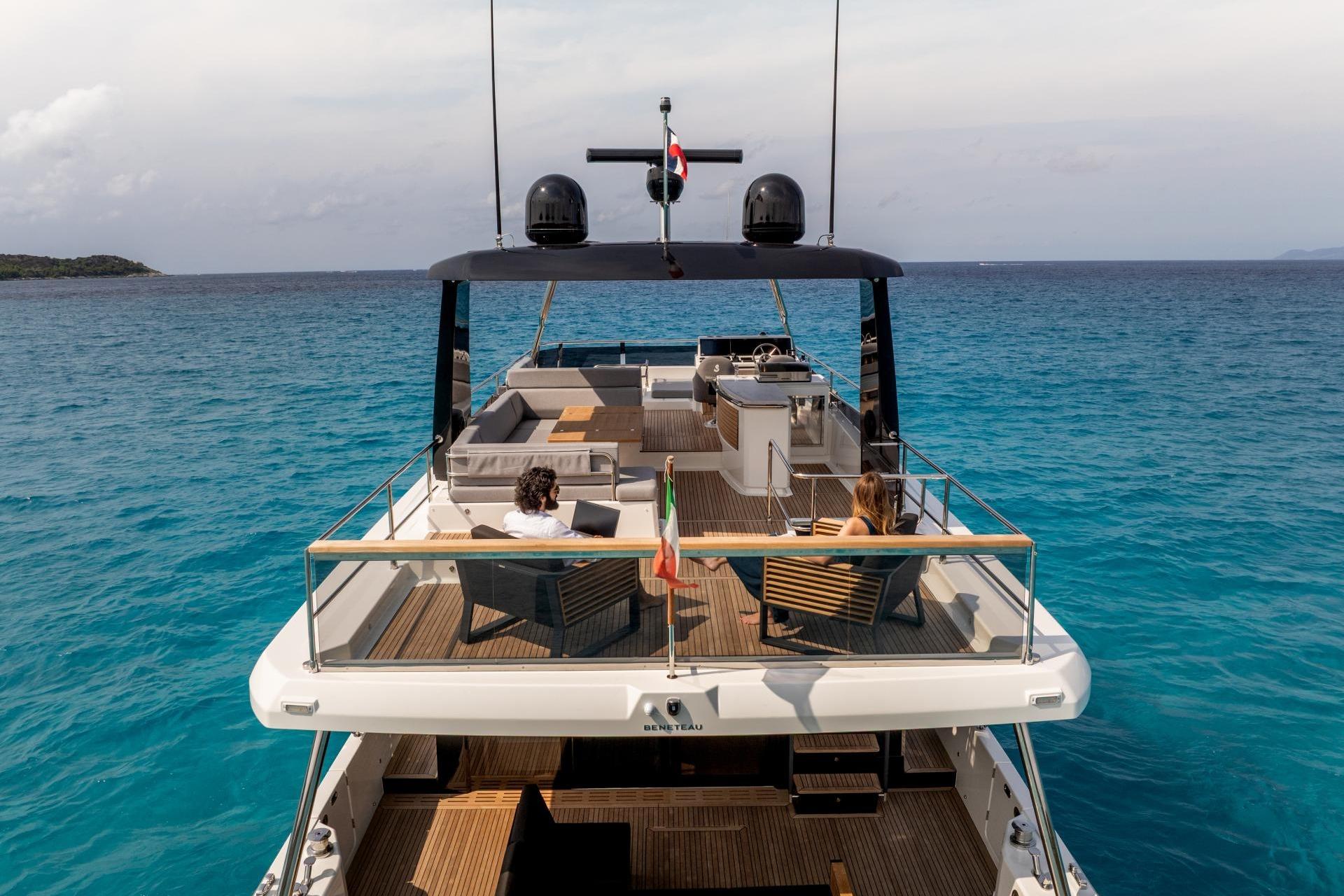 2026 Beneteau Grand Trawler 63 cruising on clear blue waters, featuring spacious deck seating.