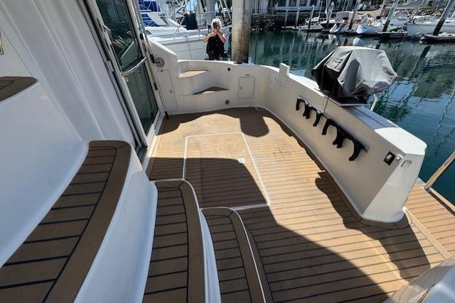 1996 Sea Ray 400 Sedan Bridge yacht deck with teak flooring and marina view.