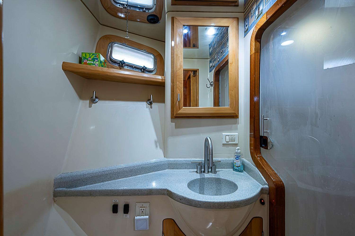 Luxurious bathroom interior of 2003 Magna Marine Nova Scotia 47 yacht, featuring modern sink and mirror.