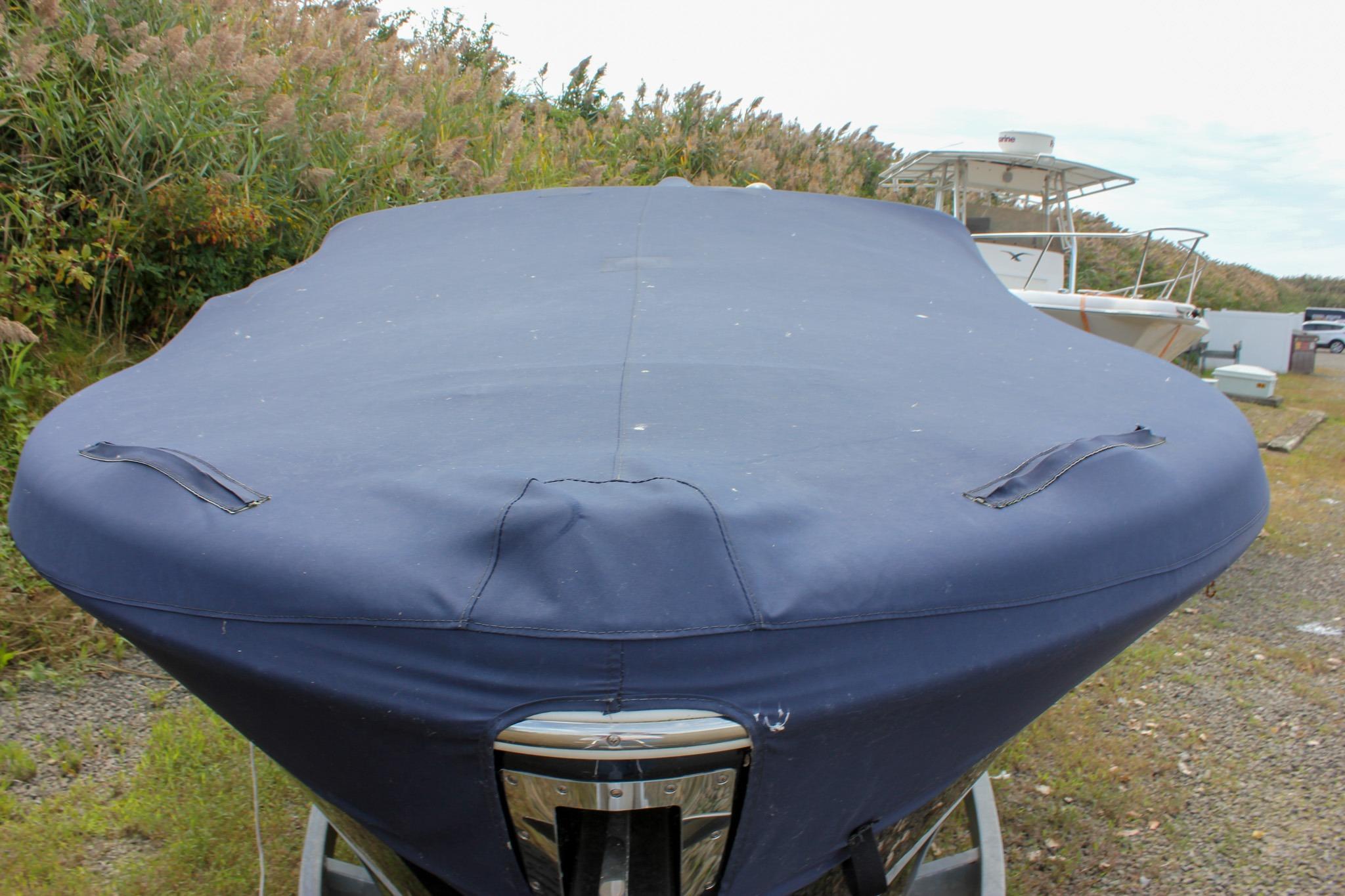 2017 Chris-Craft Capri 27 boat with blue cover, parked outdoors.