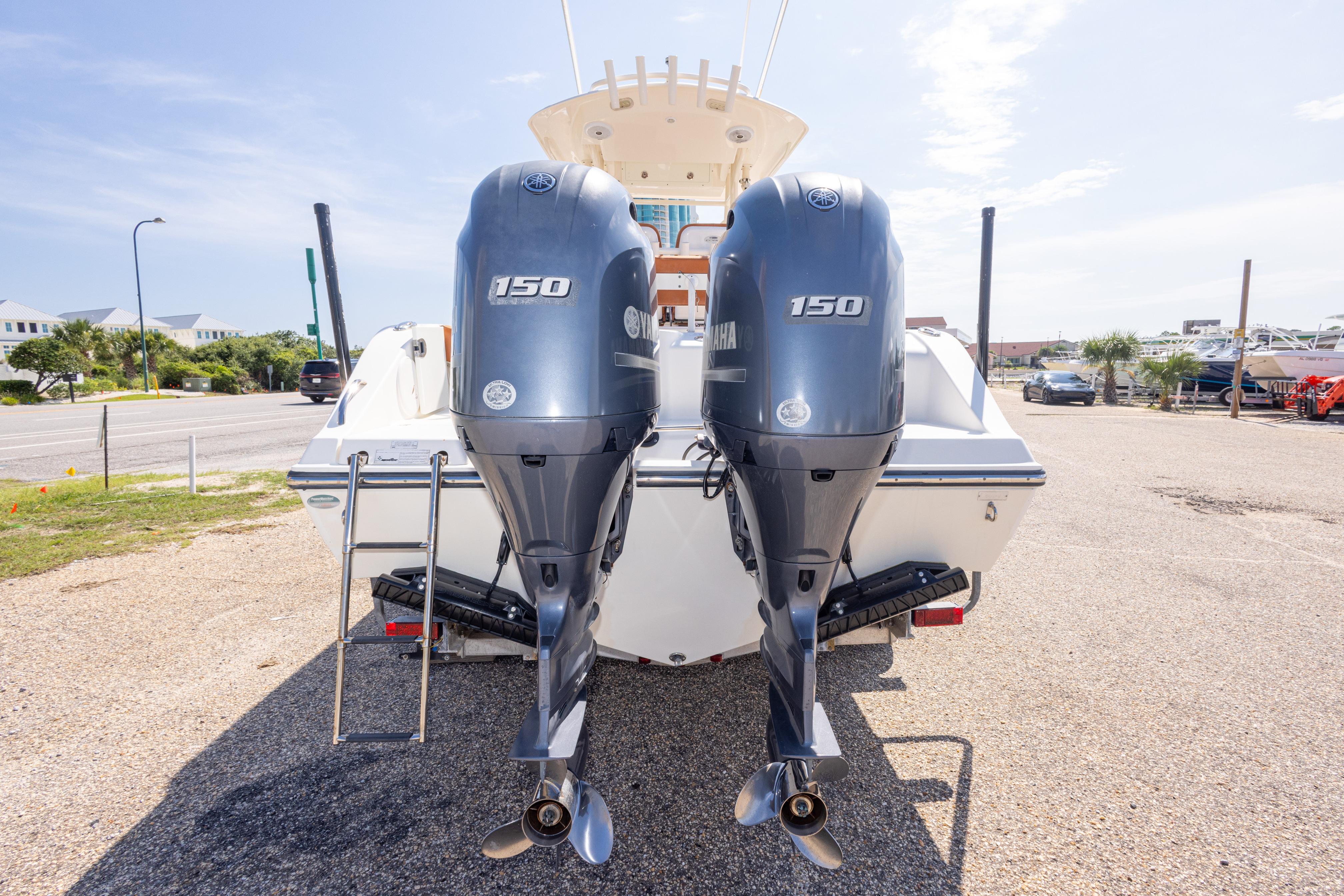 2017 Cobia 261 Center Console with dual Yamaha 150 engines, parked on a sunny day.