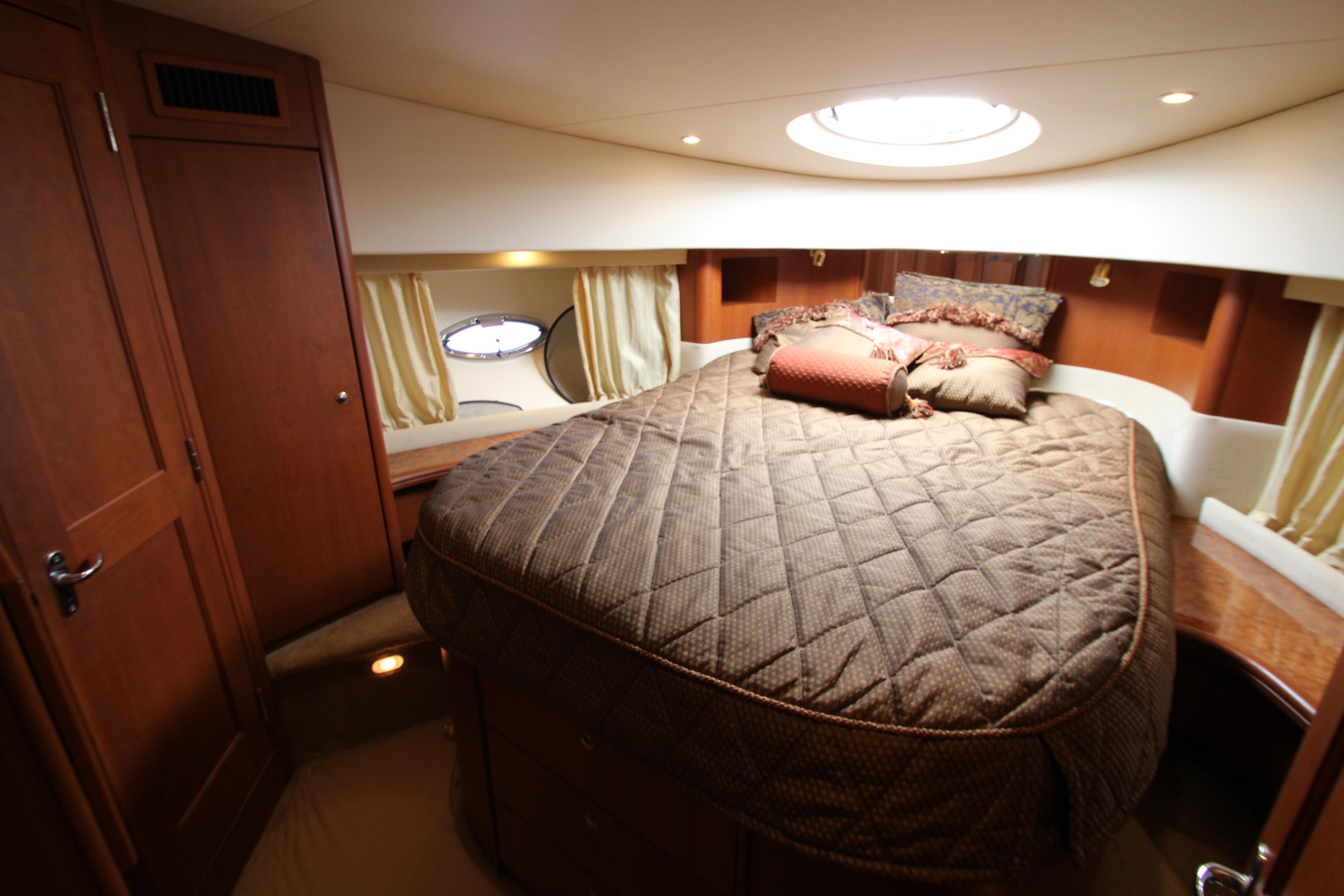 Luxurious cabin interior of 2006 Silverton 38 Sport Bridge yacht with cozy bedding.