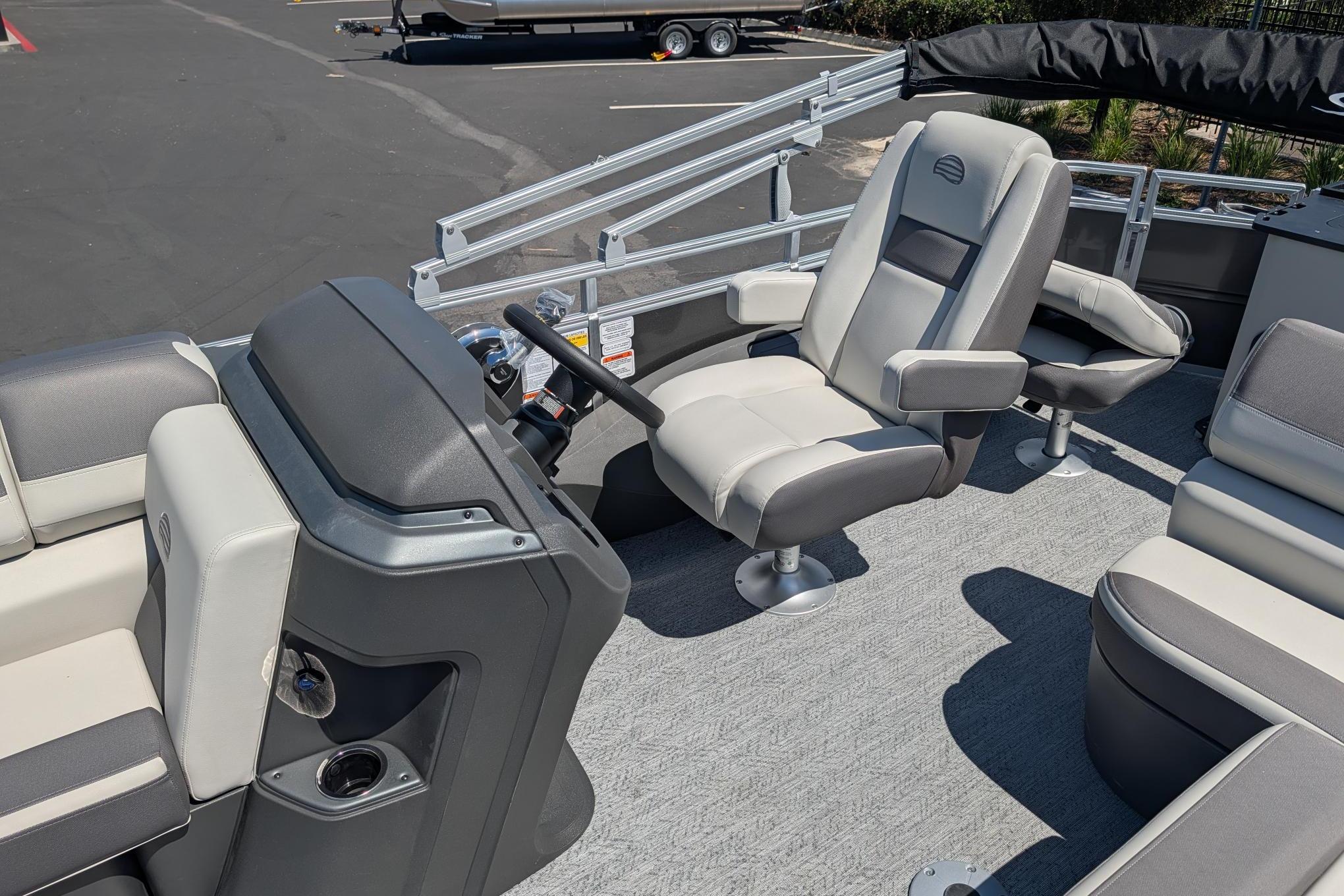 2026 Sun Tracker Fishin' Barge 22 DLX interior with steering console and seating.
