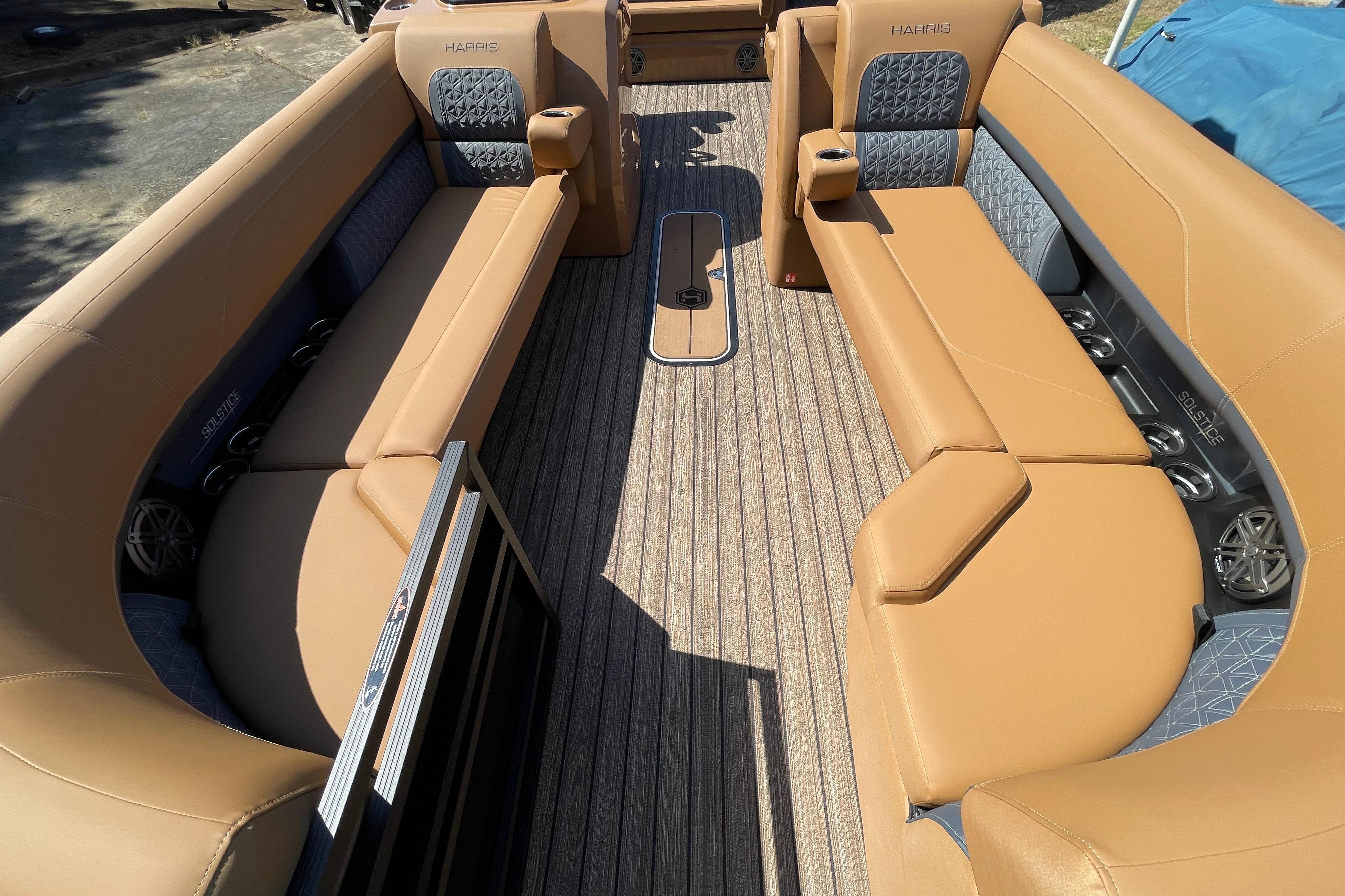 2026 Harris Solstice 250 SLDH boat interior with tan seating and wood-style flooring.