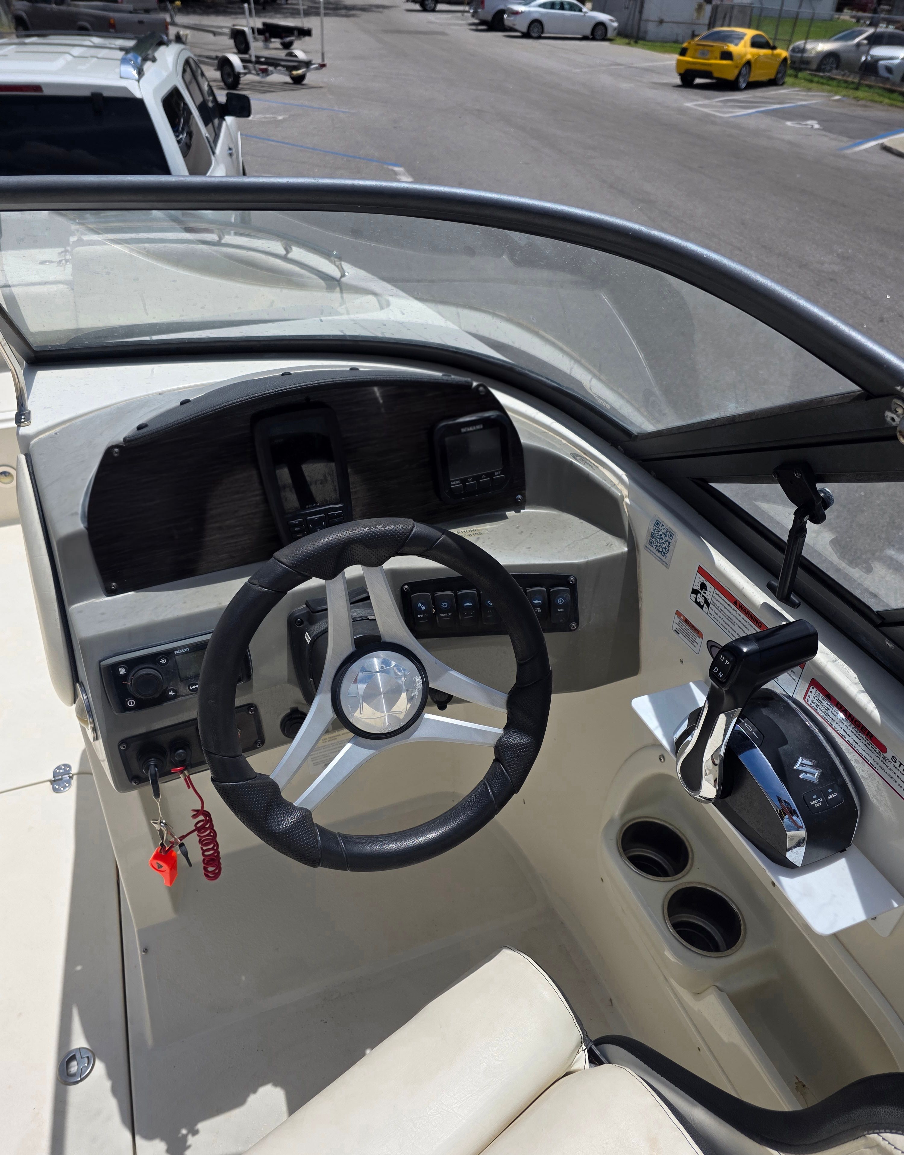The cockpit of a boat with steering wheel and controls.
