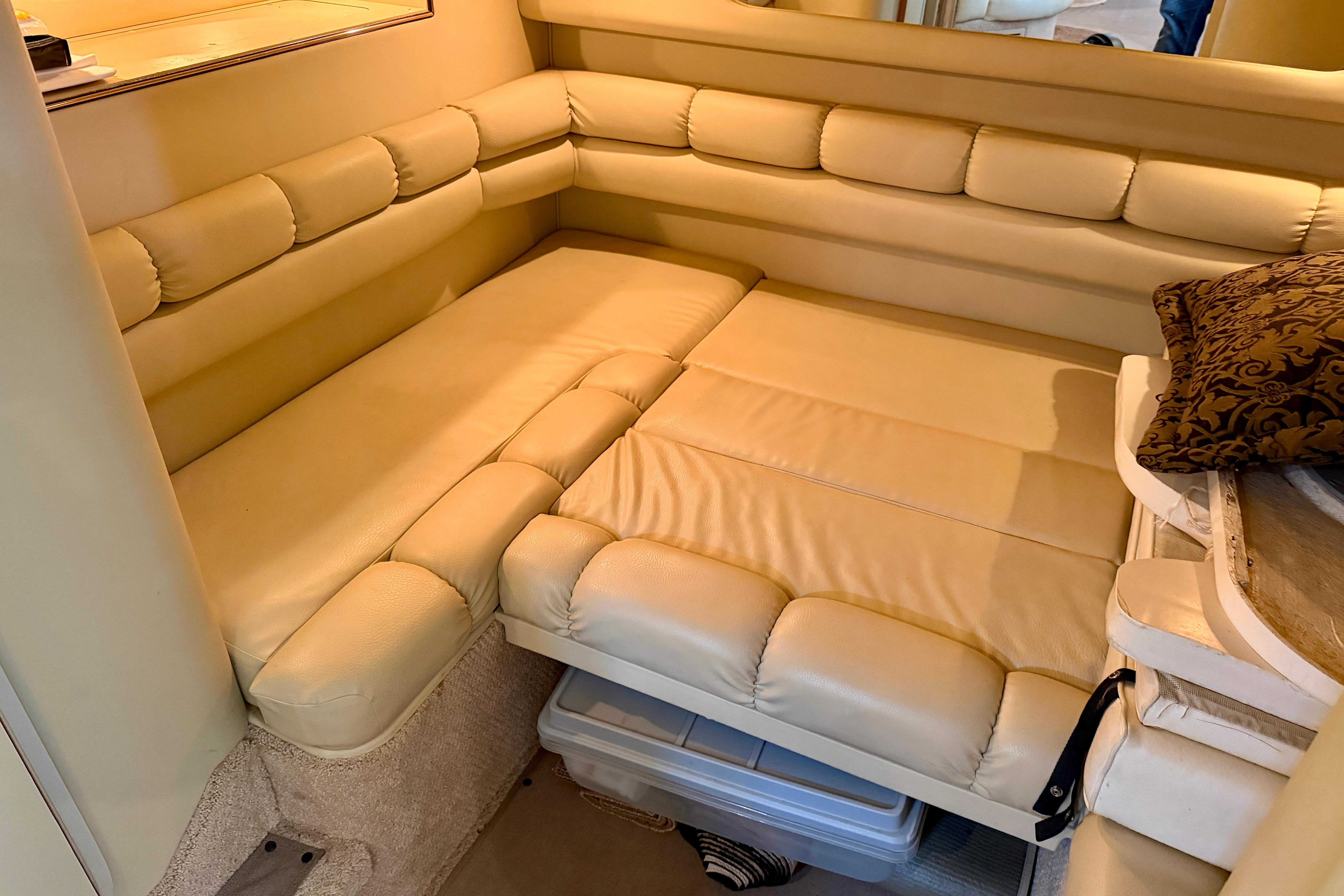 1999 Sea Ray 400 Sundancer interior with beige leather seating and decorative pillow.