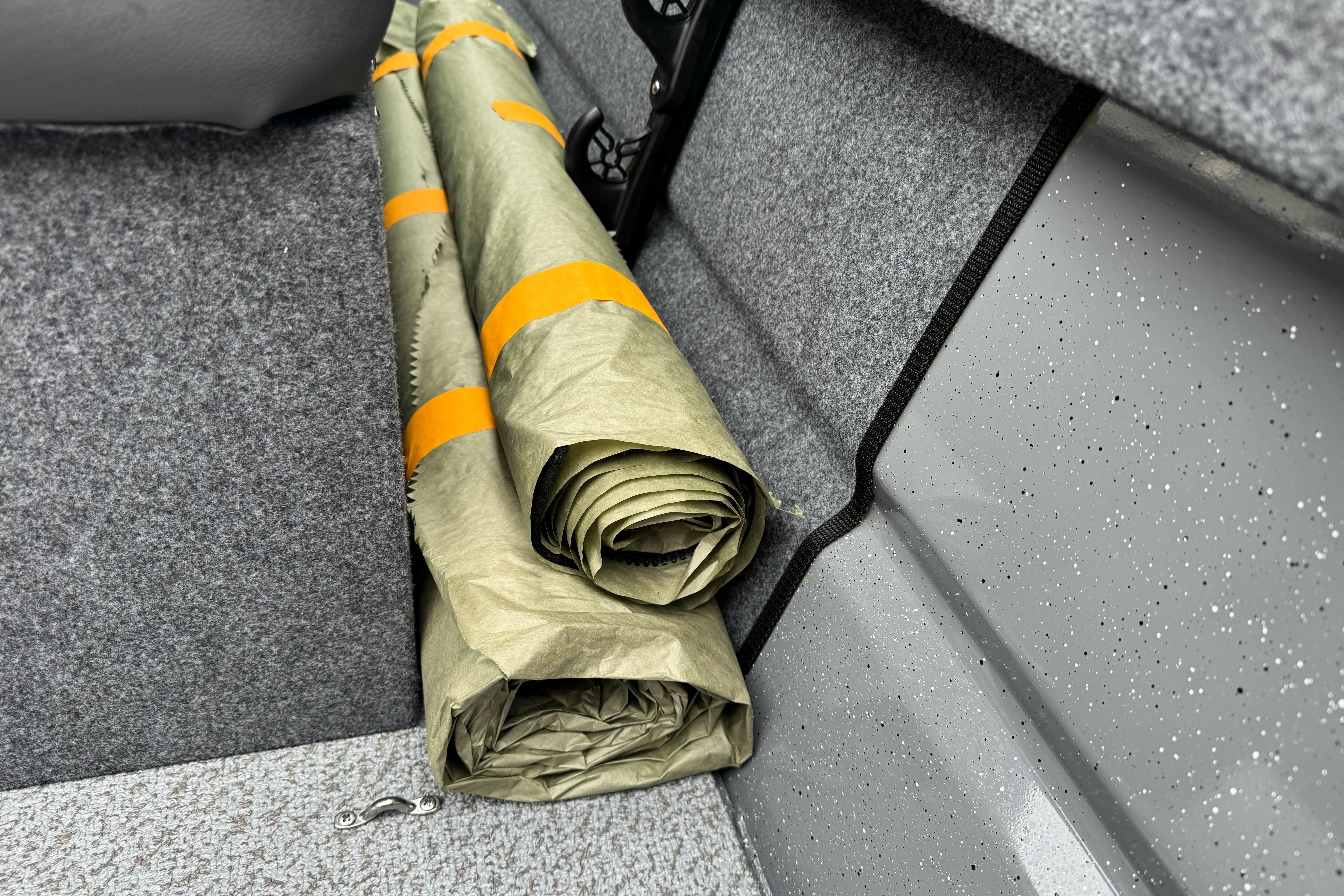 Rolled tarp stored in 2026 Lund 185 Heavy Gauge boat interior.
