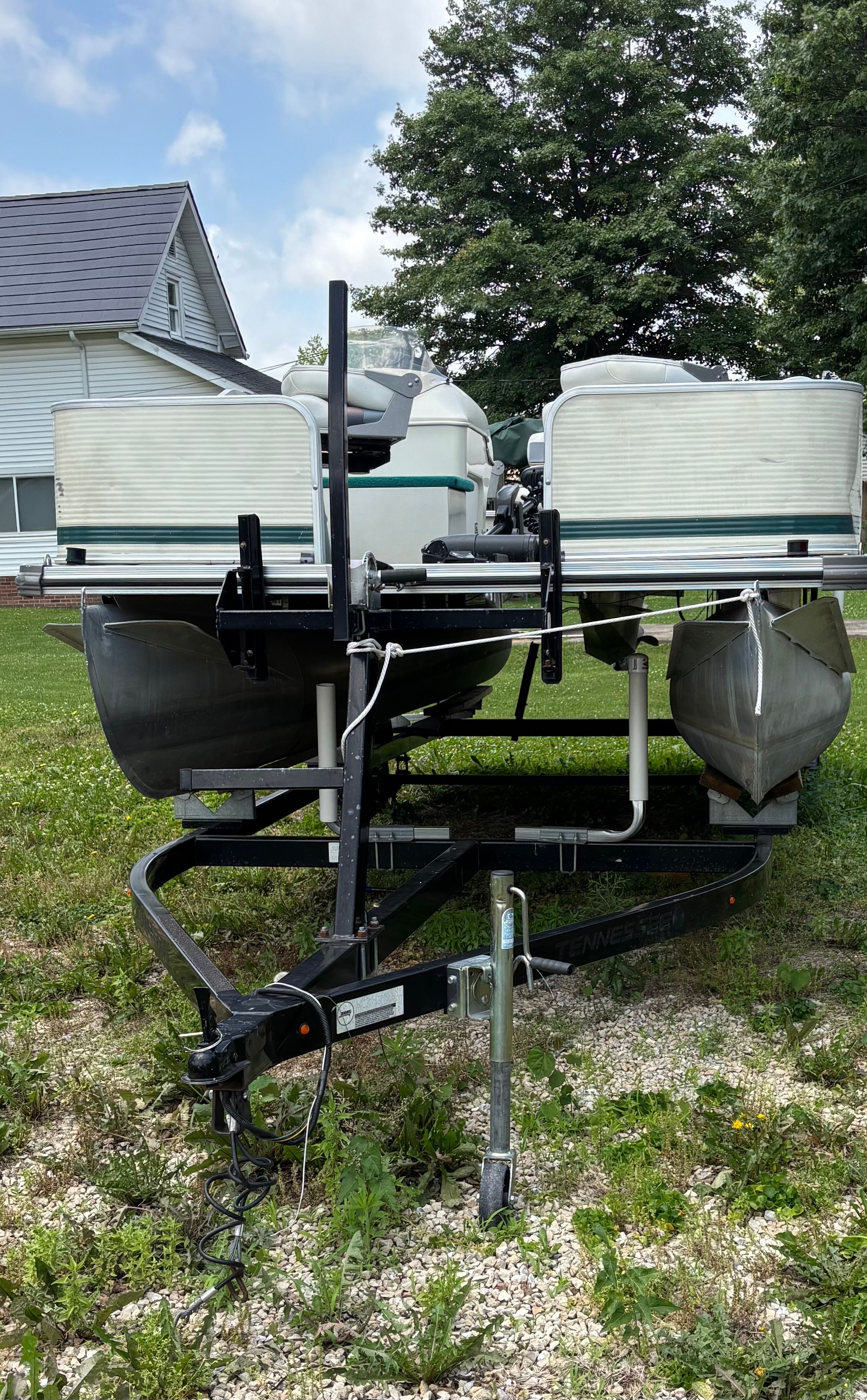 A 2001 Lowe Trinidad 204 pontoon boat is on a trailer outdoors.