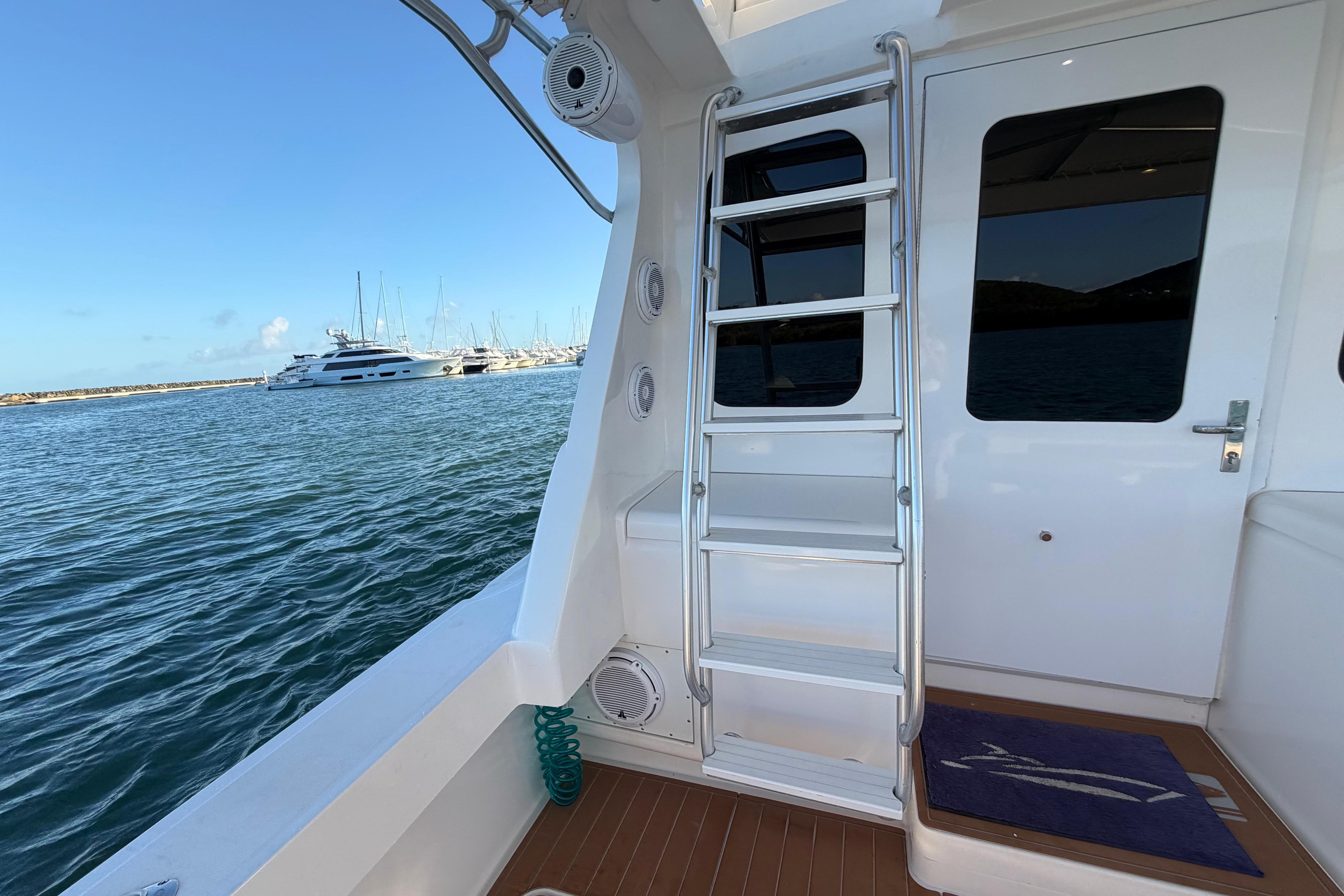 2005 Luhrs 38 Convertible yacht with ladder, docked in a marina.