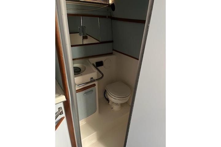 Bathroom interior of 1989 Sea Ray 300 Sundancer yacht, featuring sink and toilet.