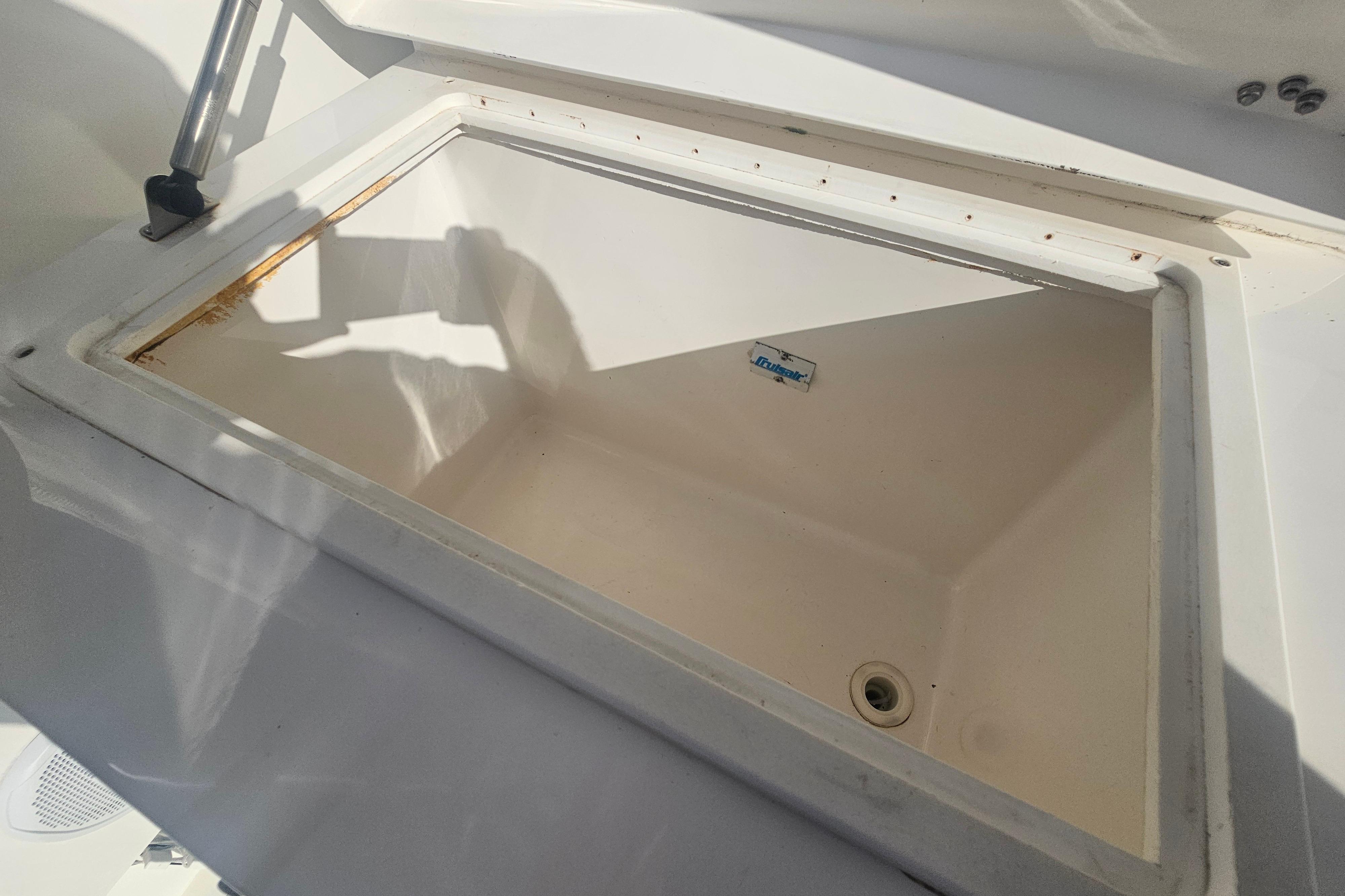 Open storage compartment on 2003 Topaz 32 Express boat, featuring a clean interior.