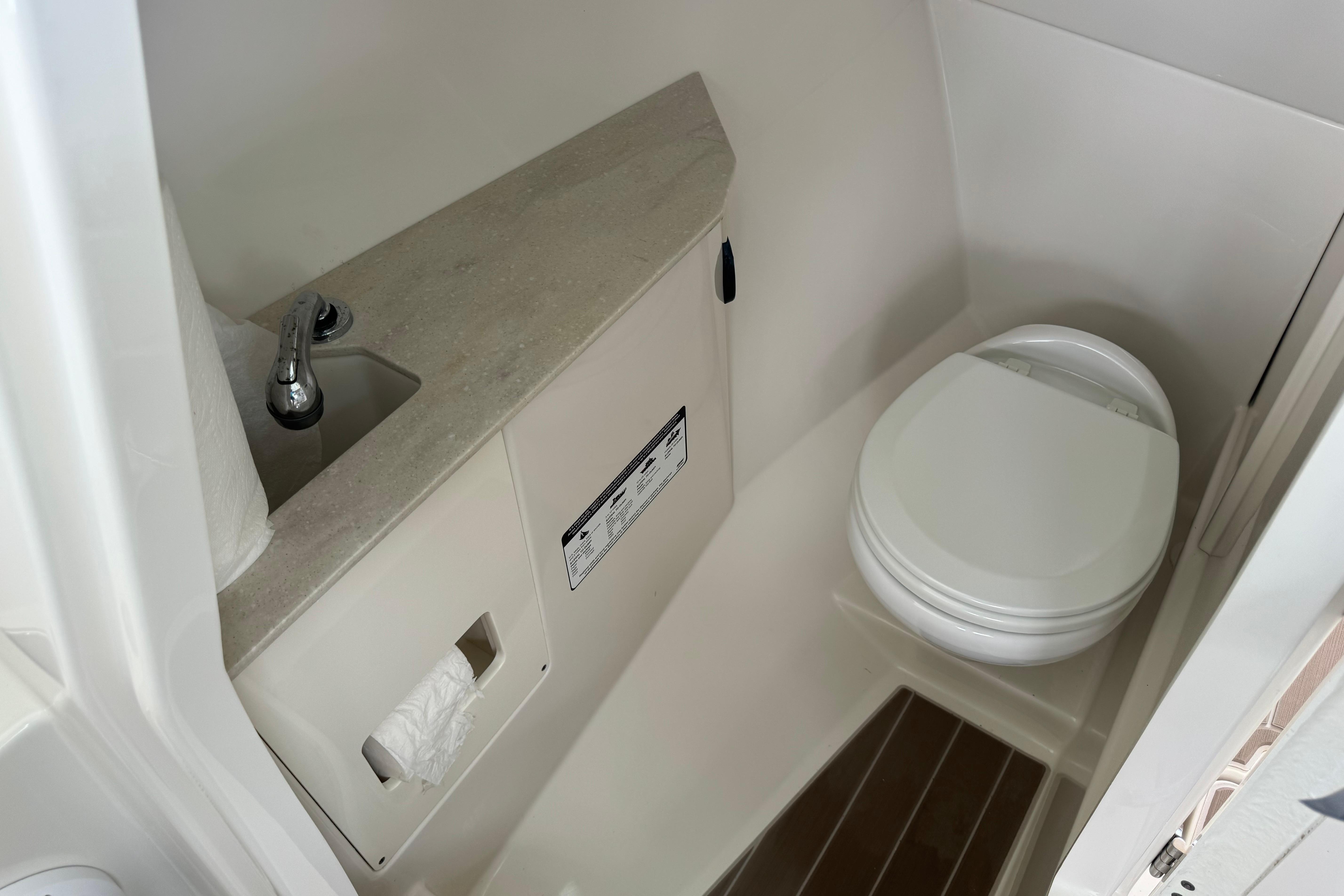 2021 Sailfish 276 DC boat bathroom with toilet and sink.