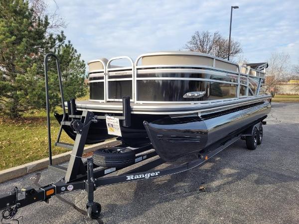 2023 Ranger Reata 243C pontoon boat on trailer in parking lot.