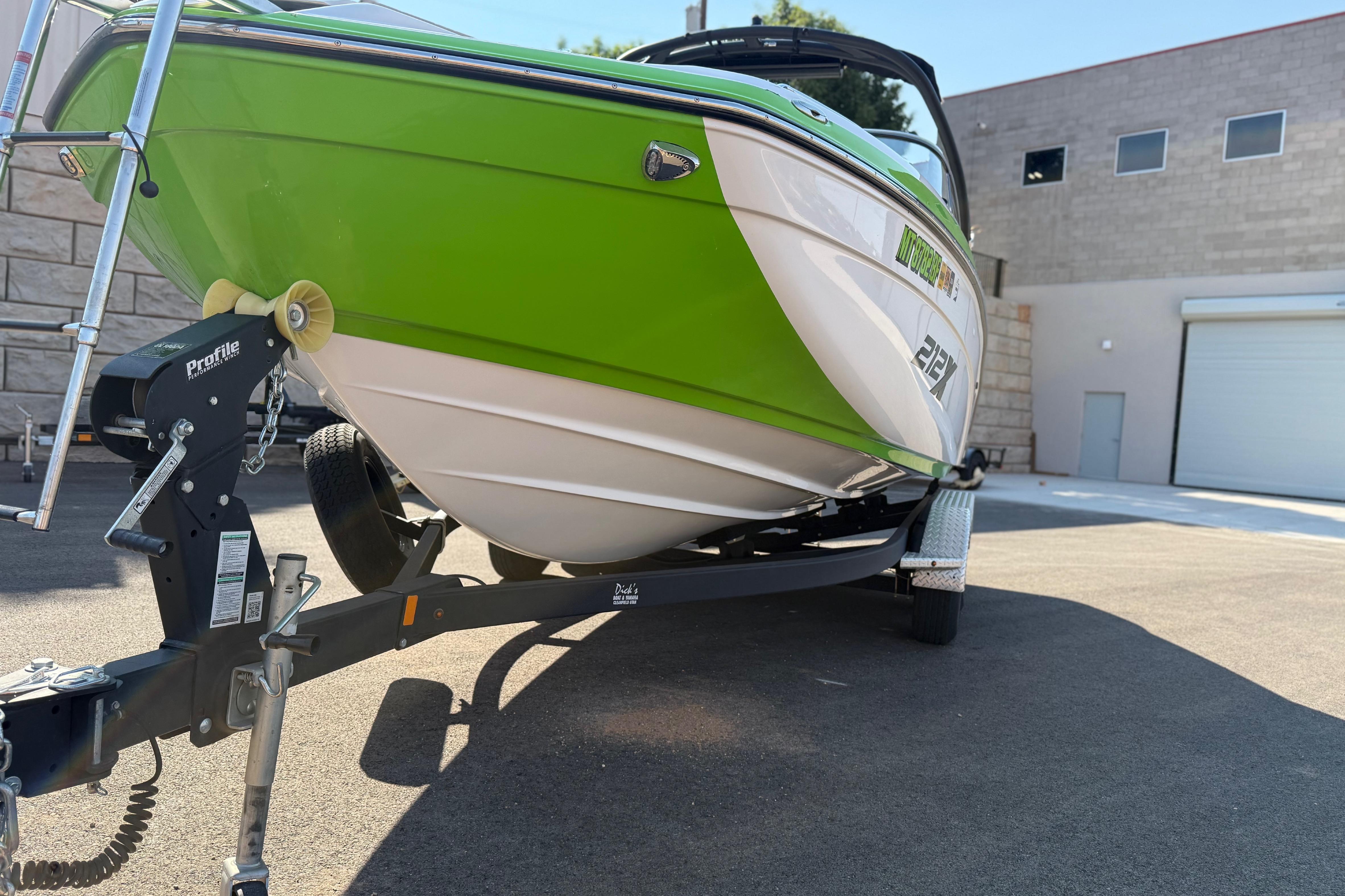 2022 Yamaha Boats 212XE in vibrant green on a trailer, parked outdoors.