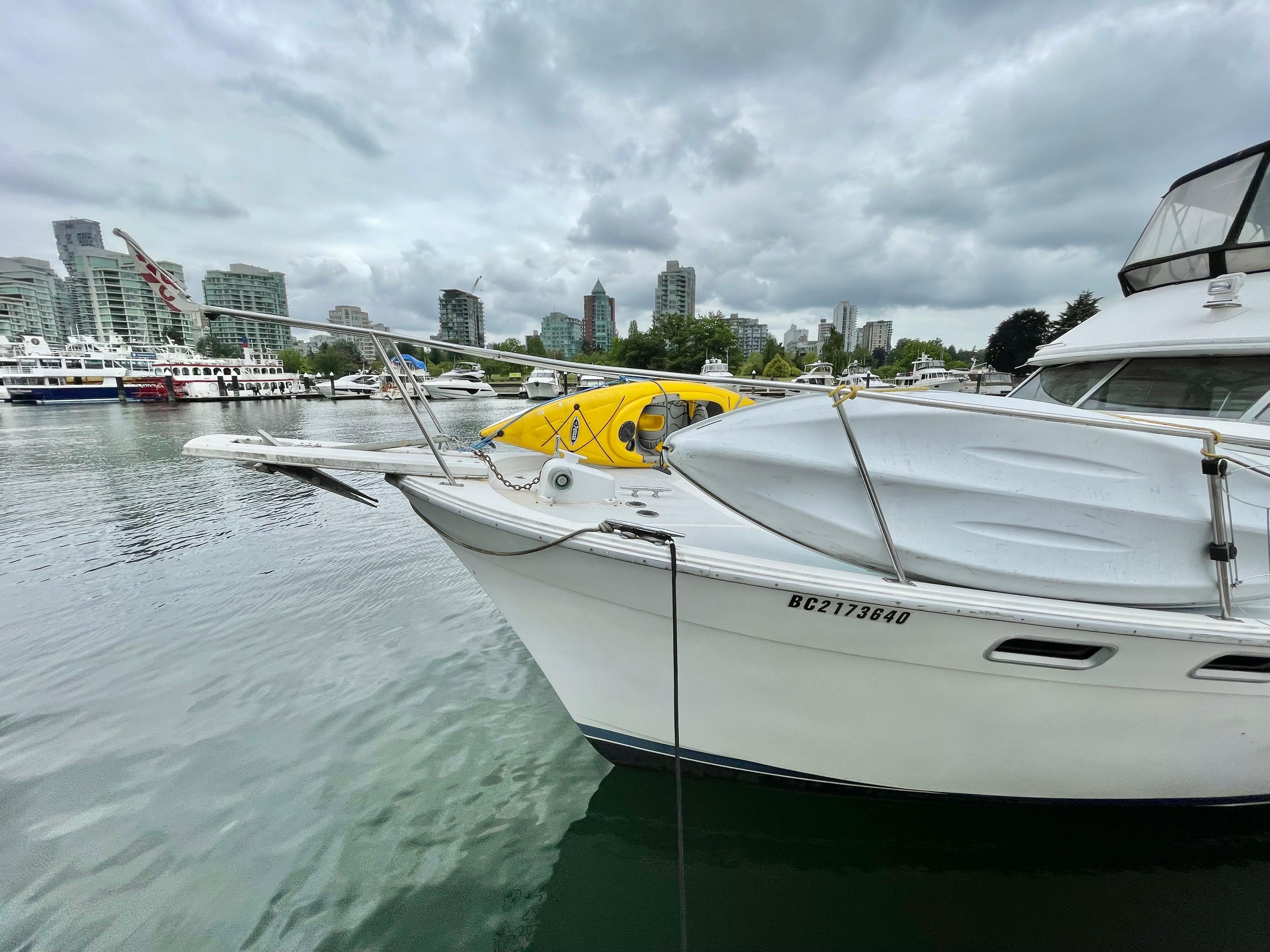 1987 Bayliner 3870 Motoryacht docked in urban marina with city skyline backdrop.