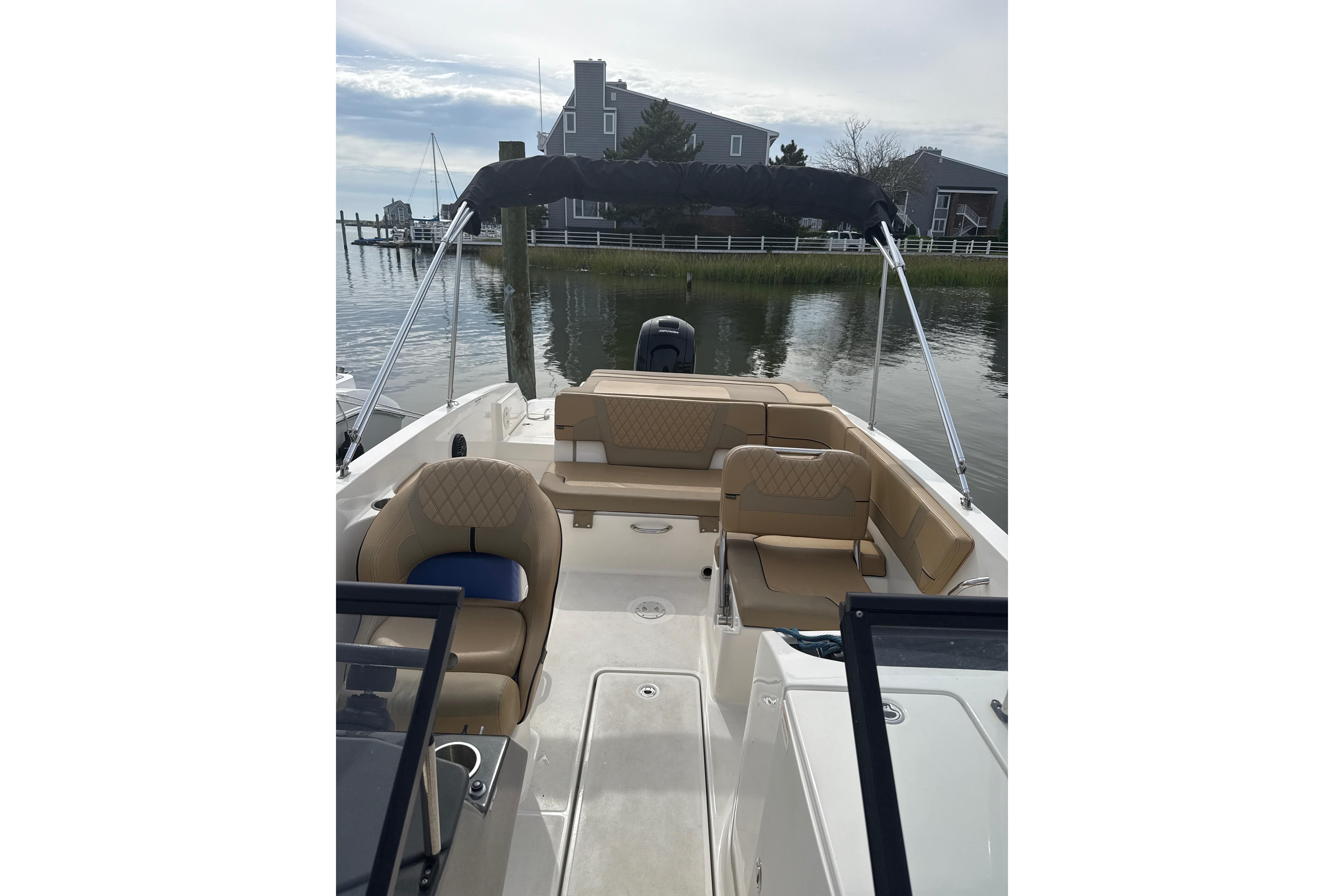 2025 Bayliner VR6 Bowrider OB with tan seating, docked near waterfront homes.
