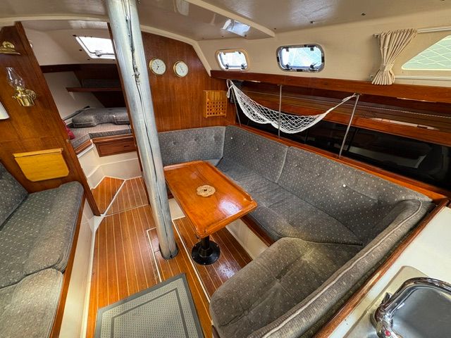 Interior of a 1989 Catalina 34 with cozy seating area and wooden table.
