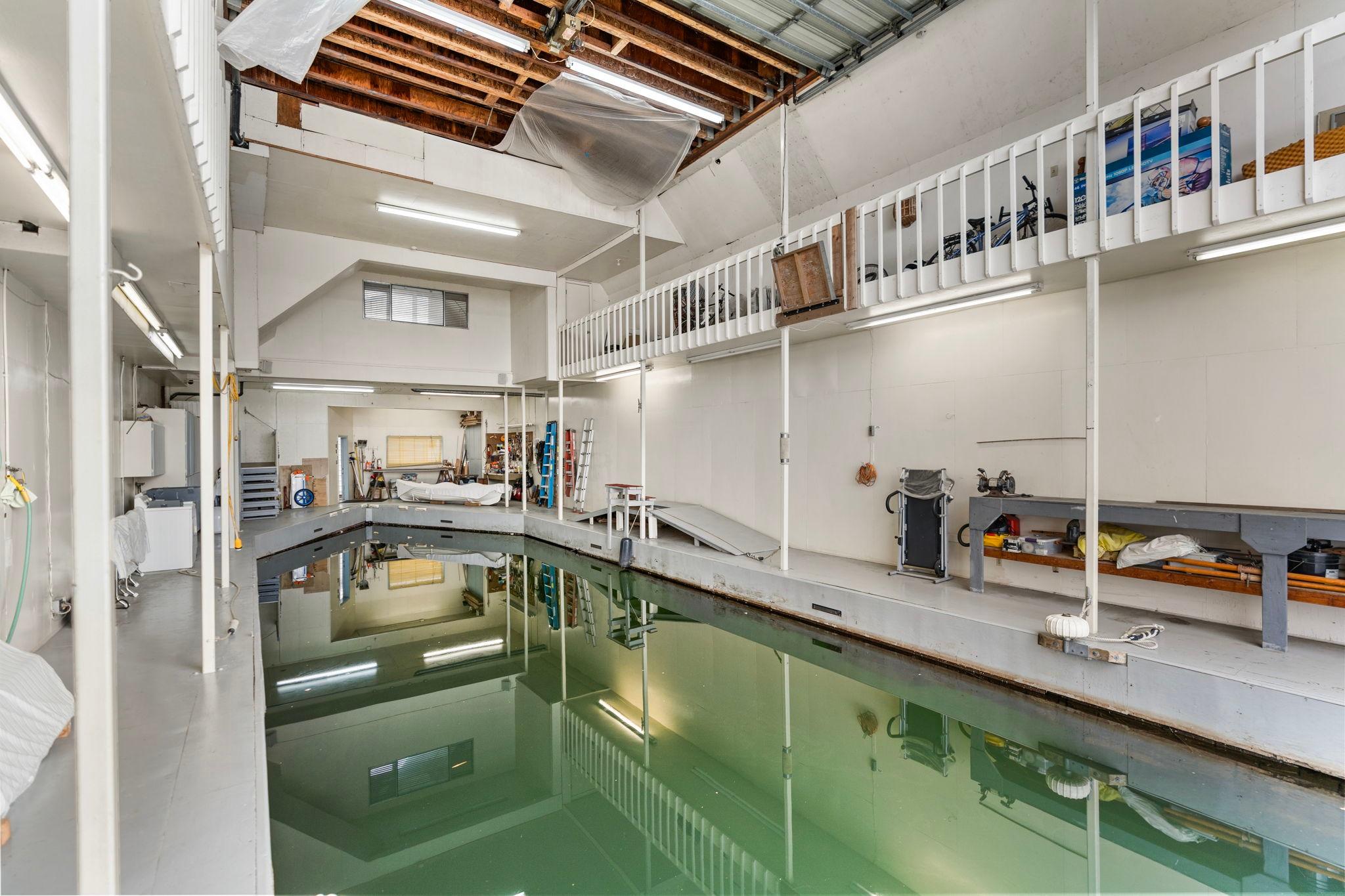 Interior of a 1976 custom boathouse with indoor water dock and storage area.