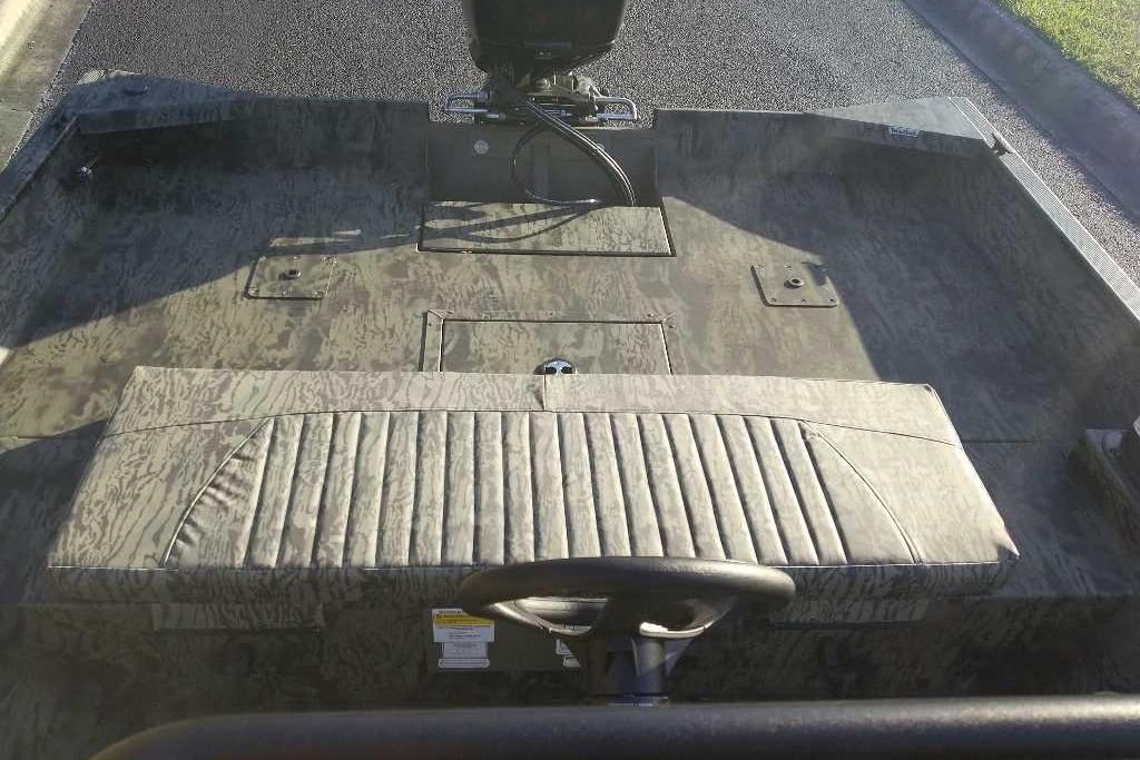 Interior view of 2026 Tracker Grizzly 2072 CC boat with camo seating and steering wheel.