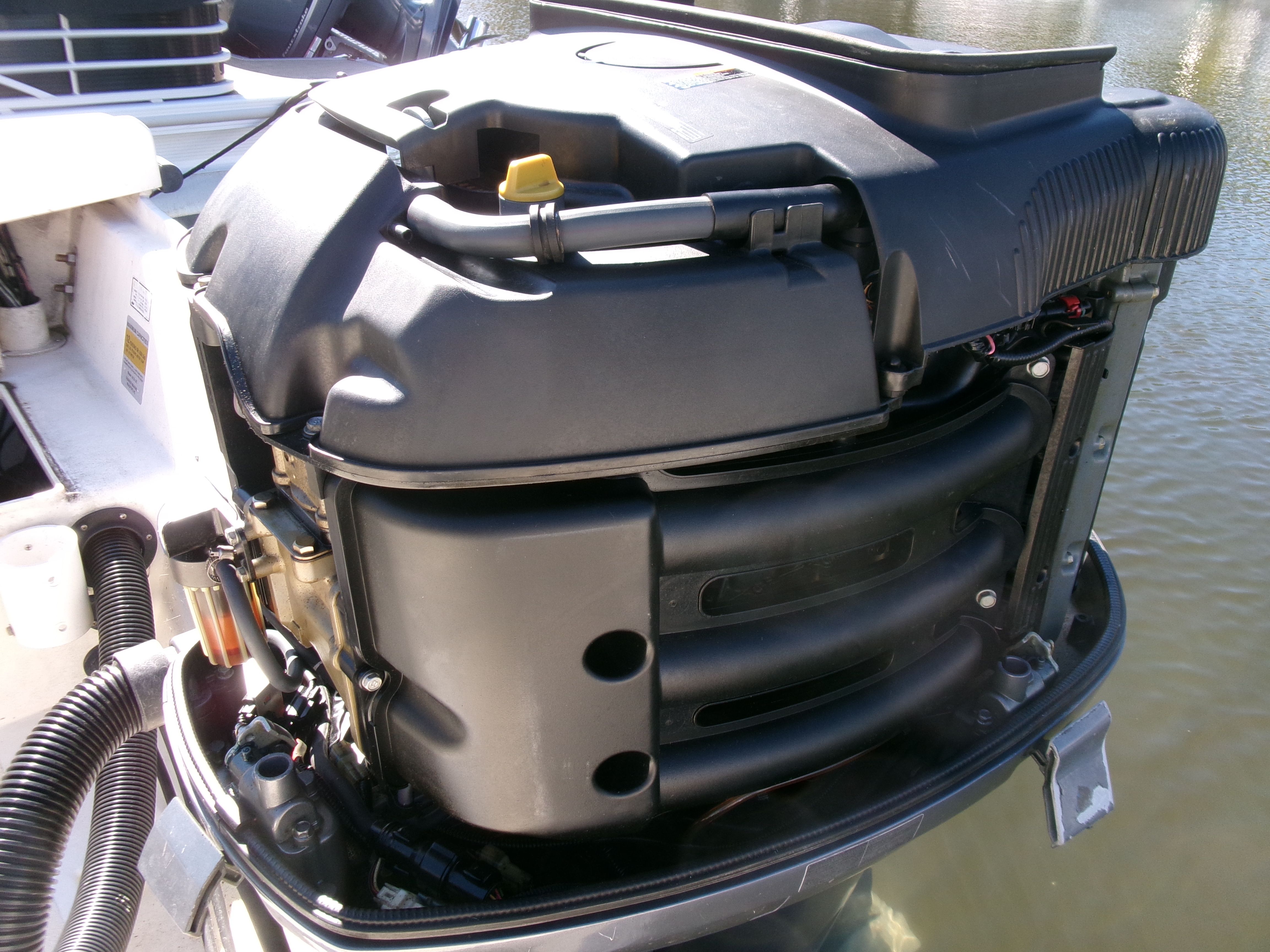 Close-up of an outboard motor on a boat sitting on the water.