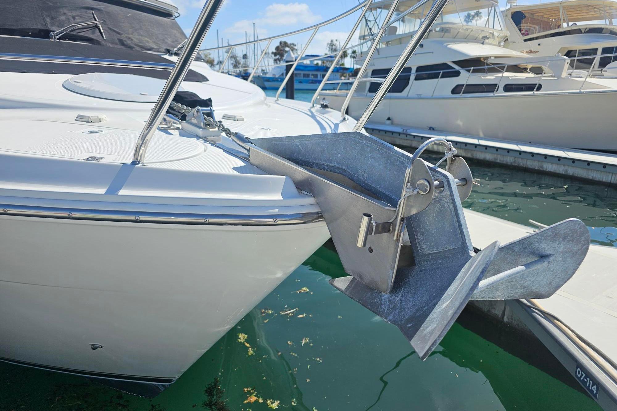 Bow of 2002 Carver 450 Voyager Pilothouse with anchor in marina setting.