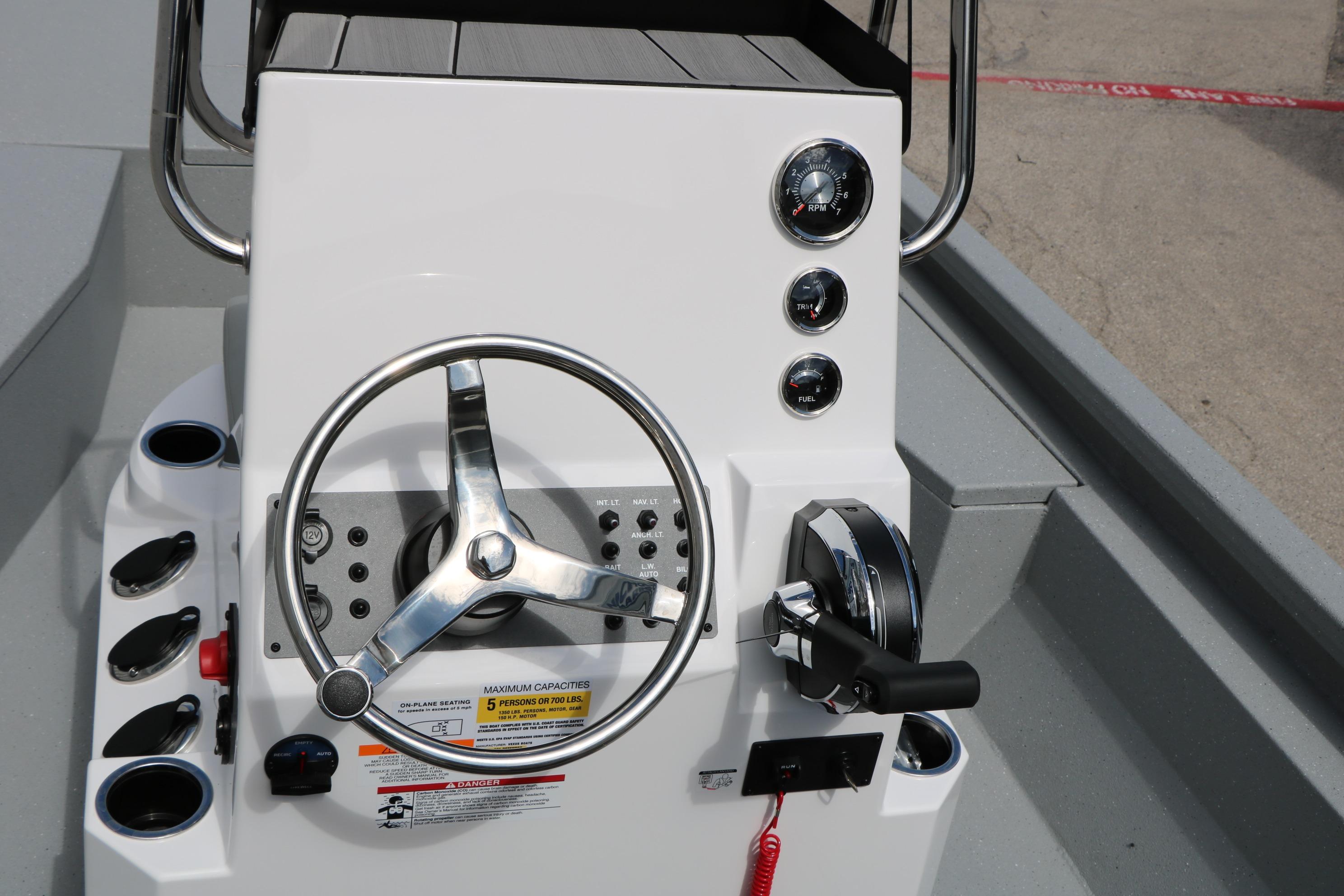Steering console of 2026 Vexus Defender 201 boat with gauges and controls.