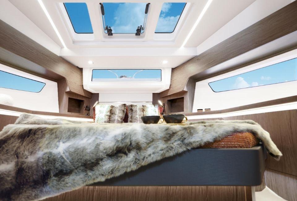 Luxurious interior of 2025 Sealine F430 yacht with skylights and plush bedding.