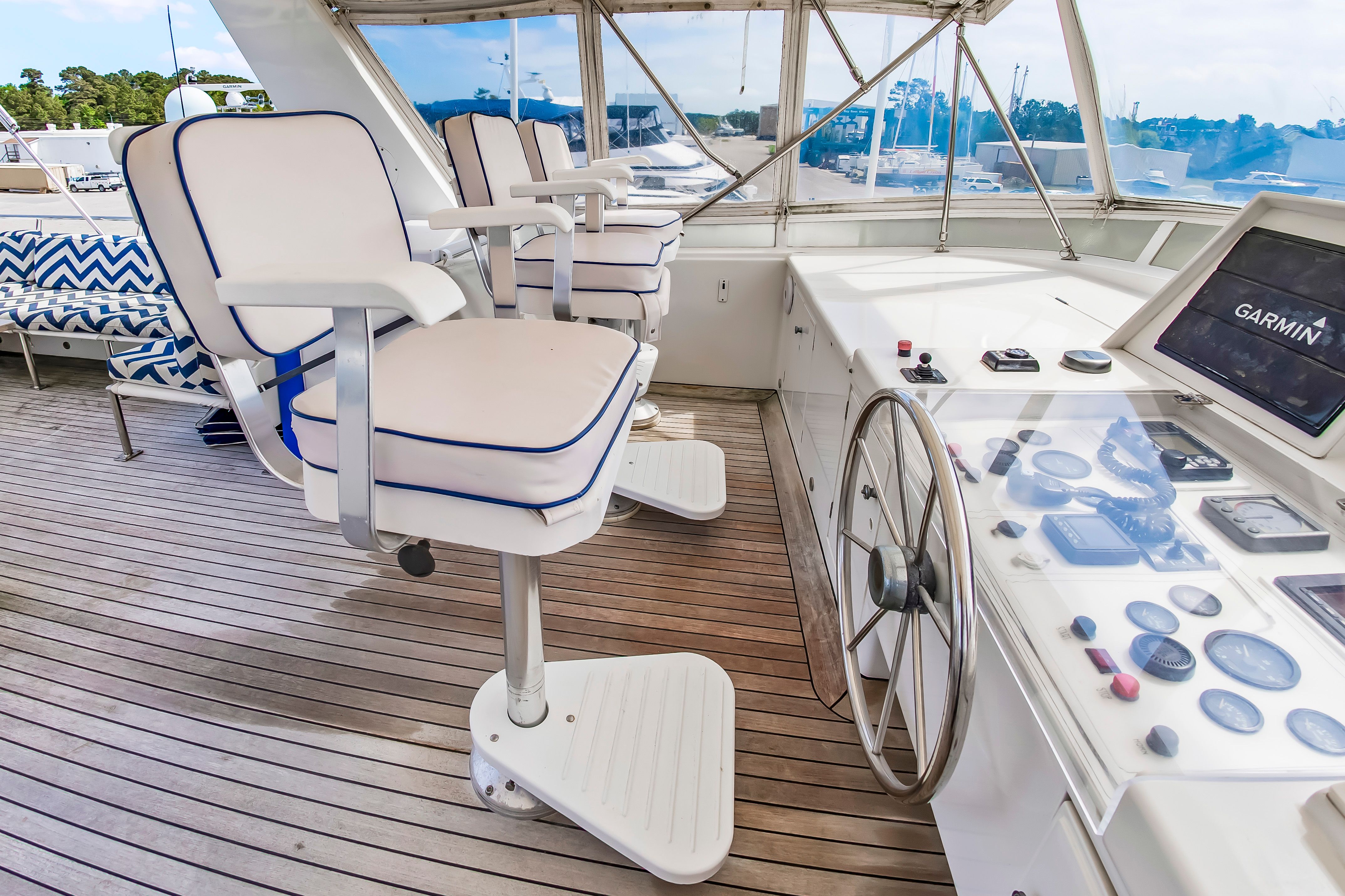 The image shows the helm of a 1987 Jongert 78 Motor Yacht with white seats and a steering wheel.