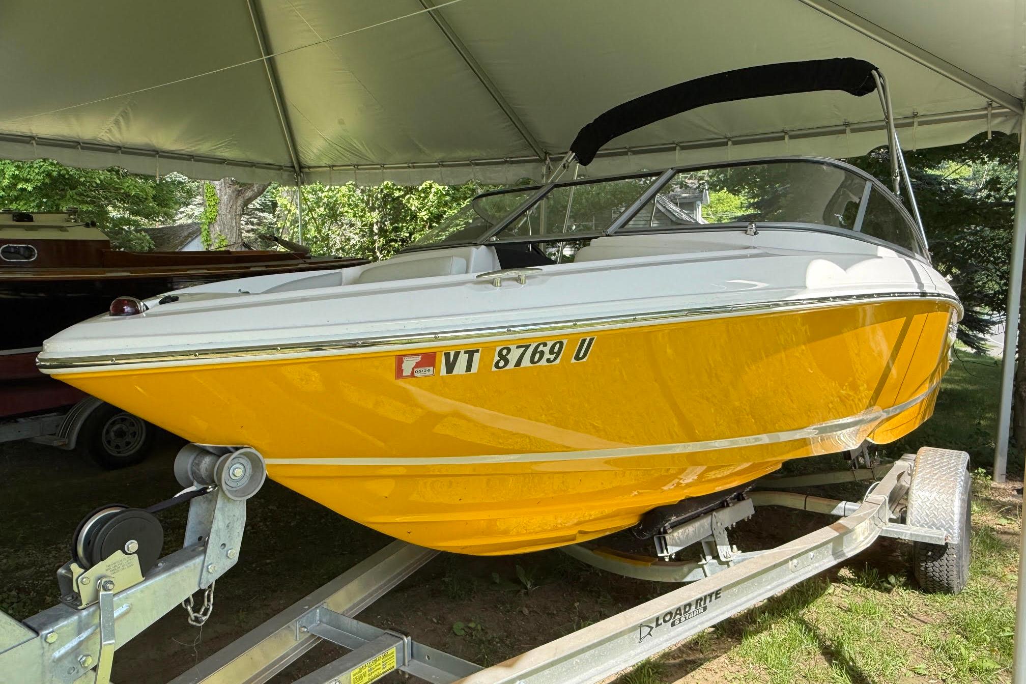 2016 Regal 1900 ES Bowrider in vibrant yellow on trailer under canopy.