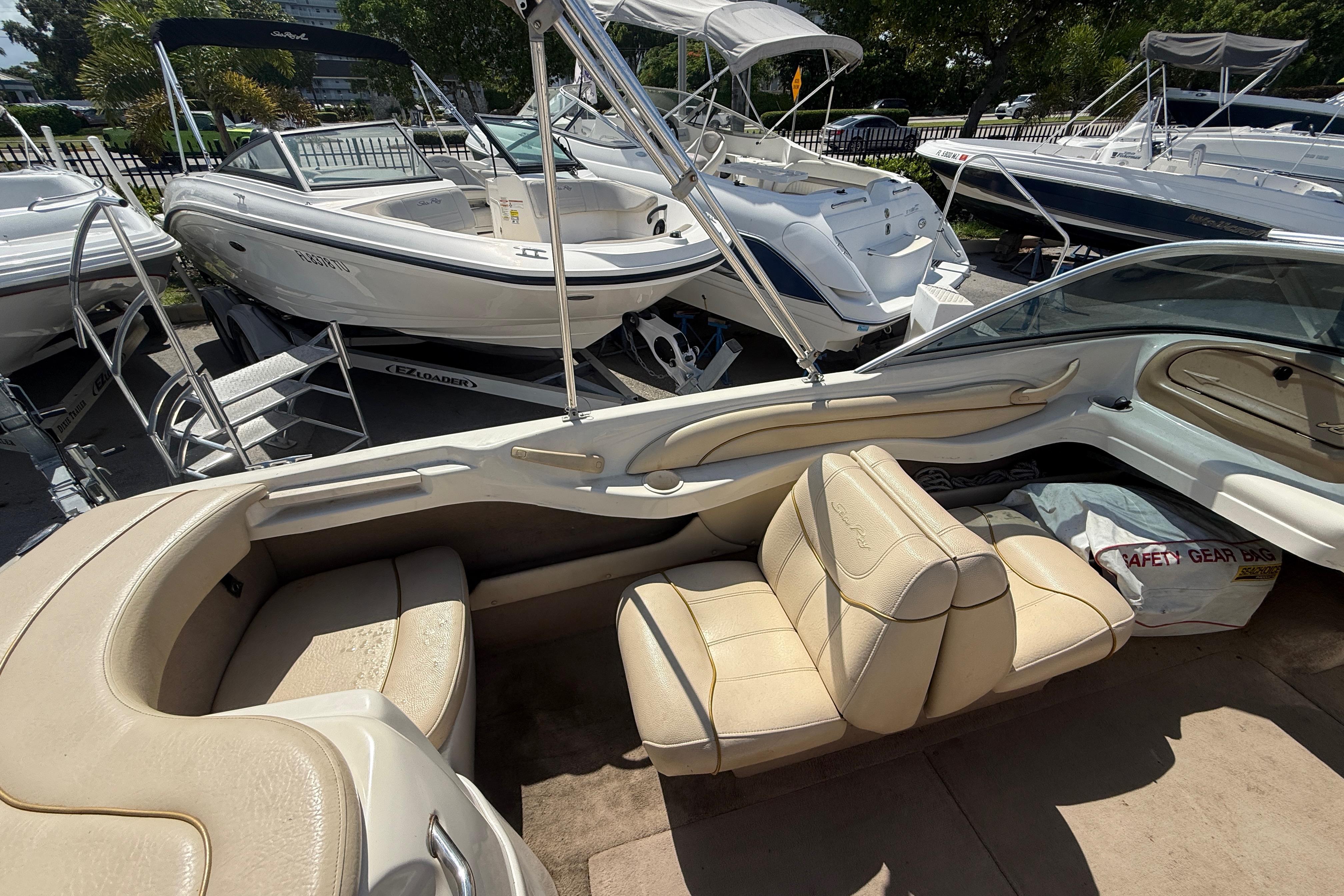 2001 Sea Ray 180 Bow Rider interior with beige seating, parked among other boats.