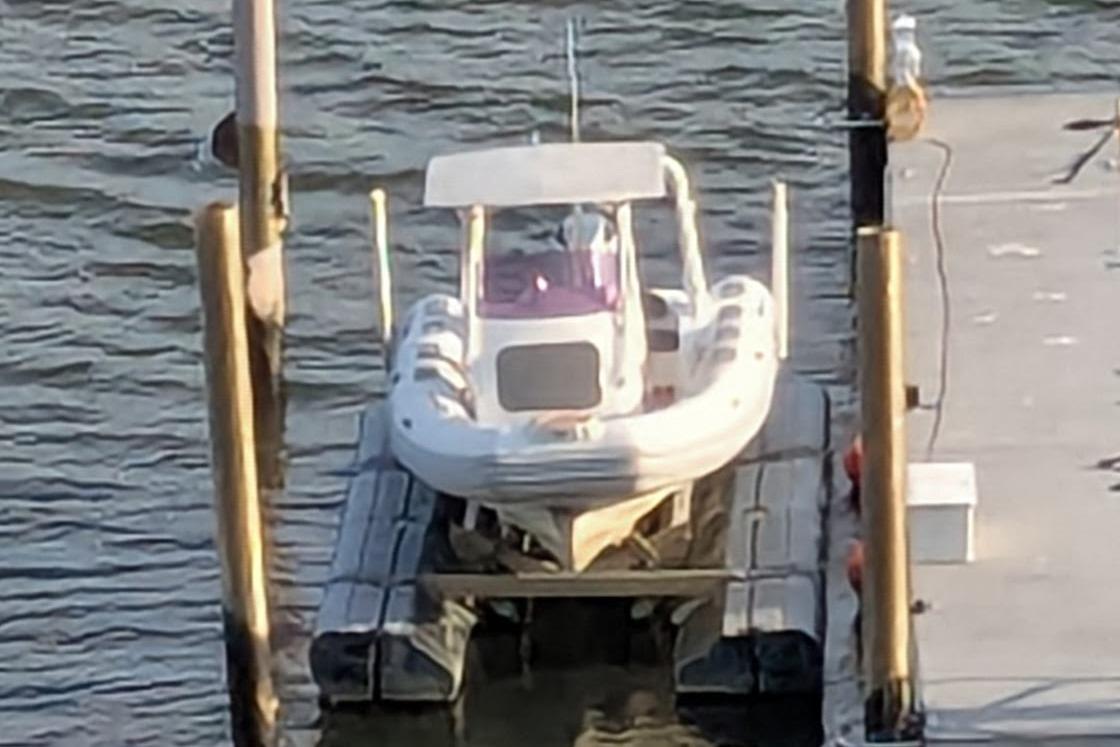 2016 Brig E780 boat docked on a lift at a marina.