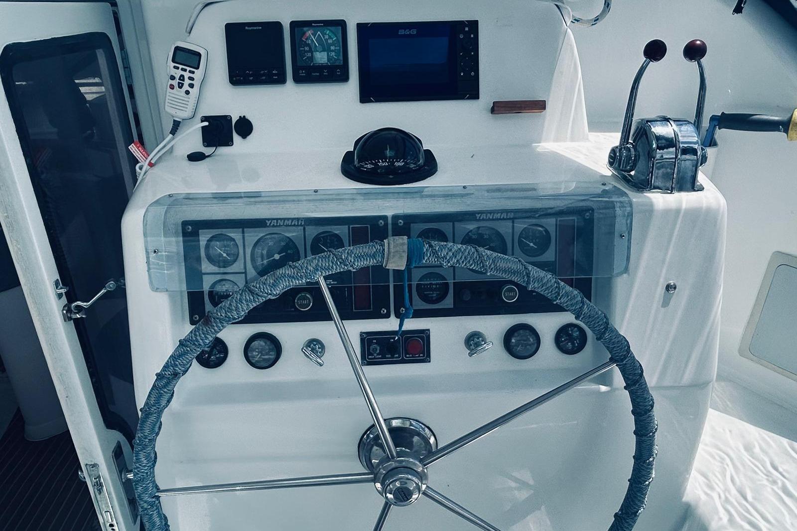 Helm of 2001 Robertson & Caine Leopard yacht with navigation instruments and steering wheel.