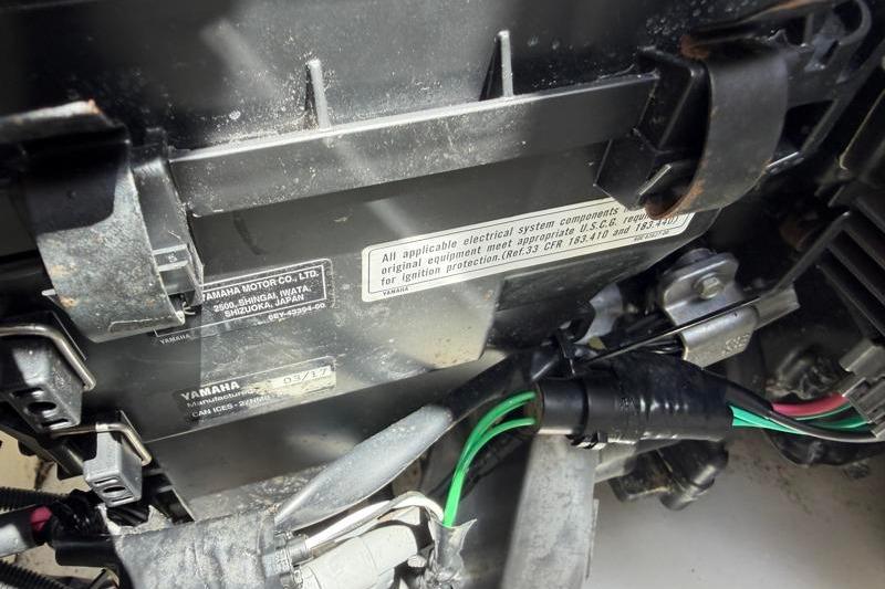 Close-up of a 2017 Yamaha Boats SX210 engine component with wiring and labels.