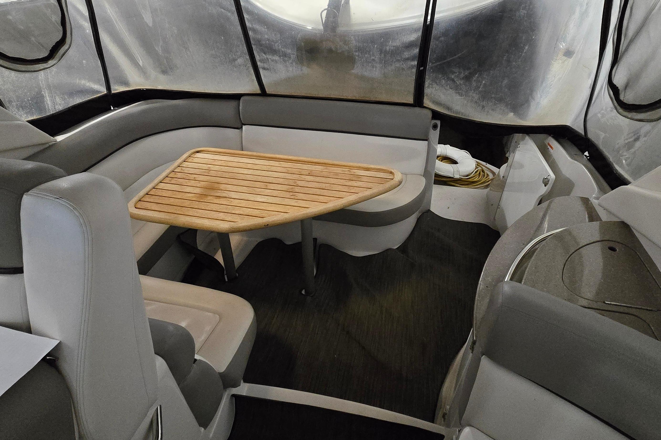 Interior of 2018 Four Winns V355 boat with seating and wooden table.