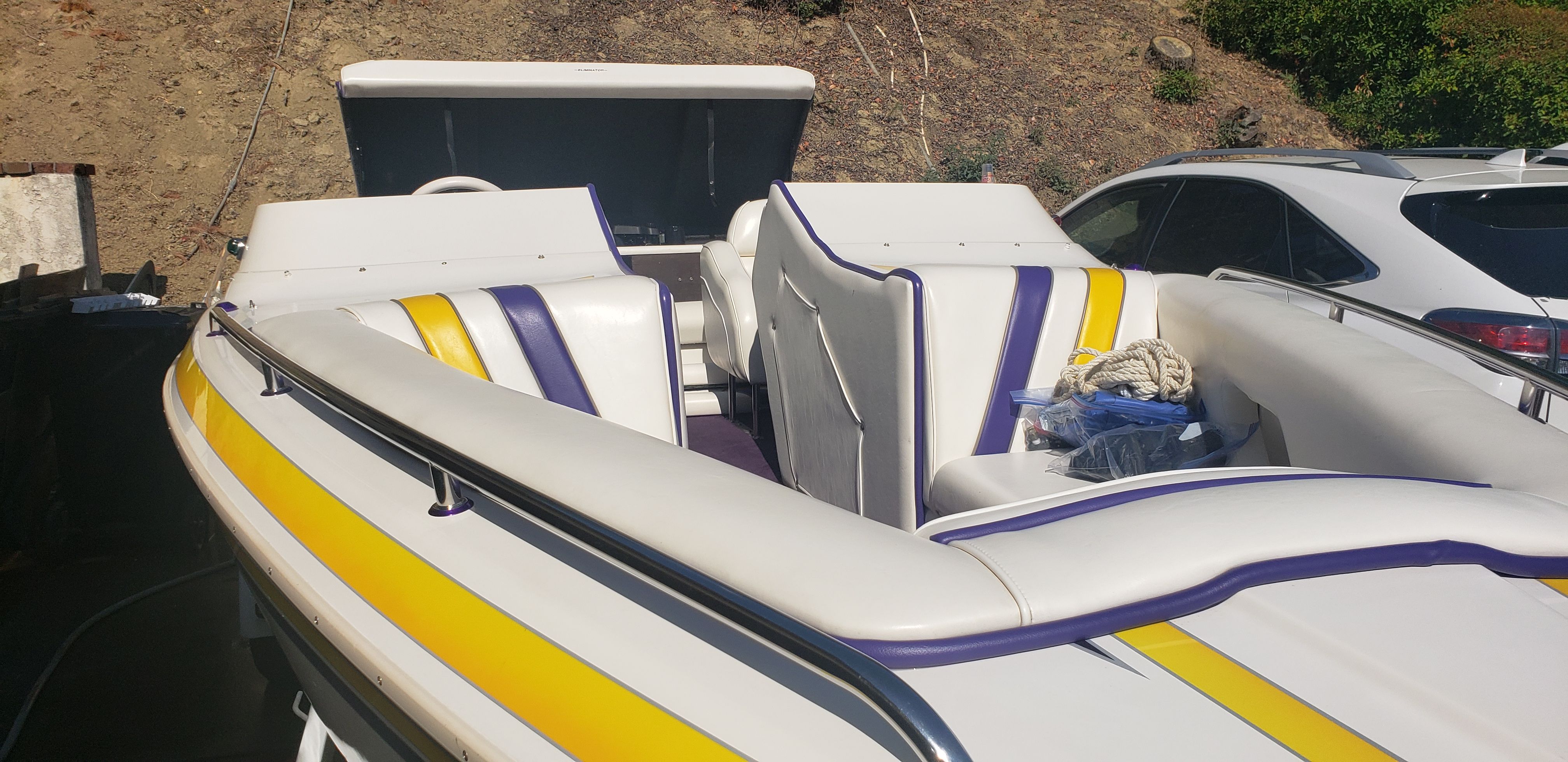 1999 Eliminator 220 Eagle XP boat with yellow and purple accents.