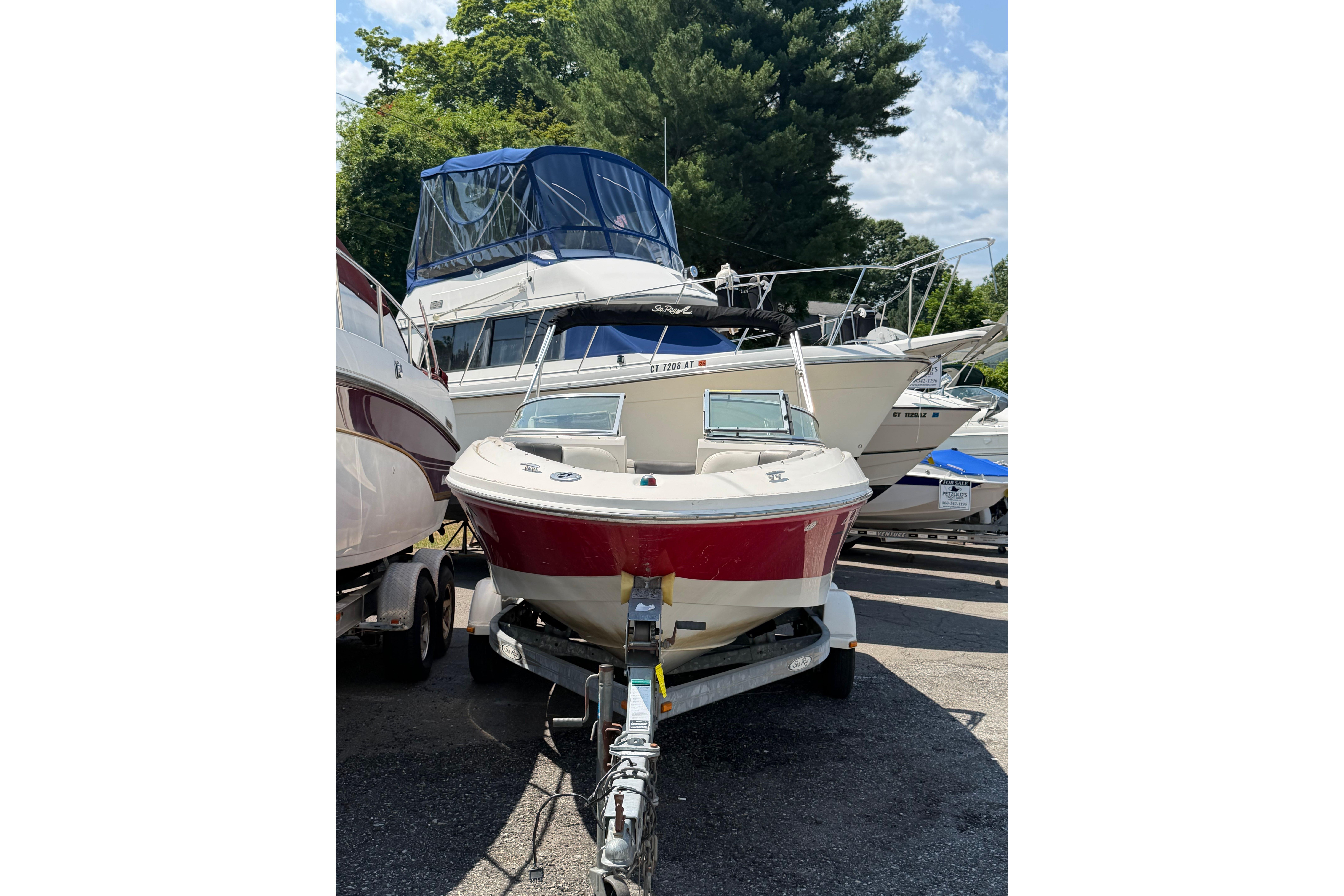 2006 Sea Ray 195 Sport boat on trailer, surrounded by other boats, outdoors.