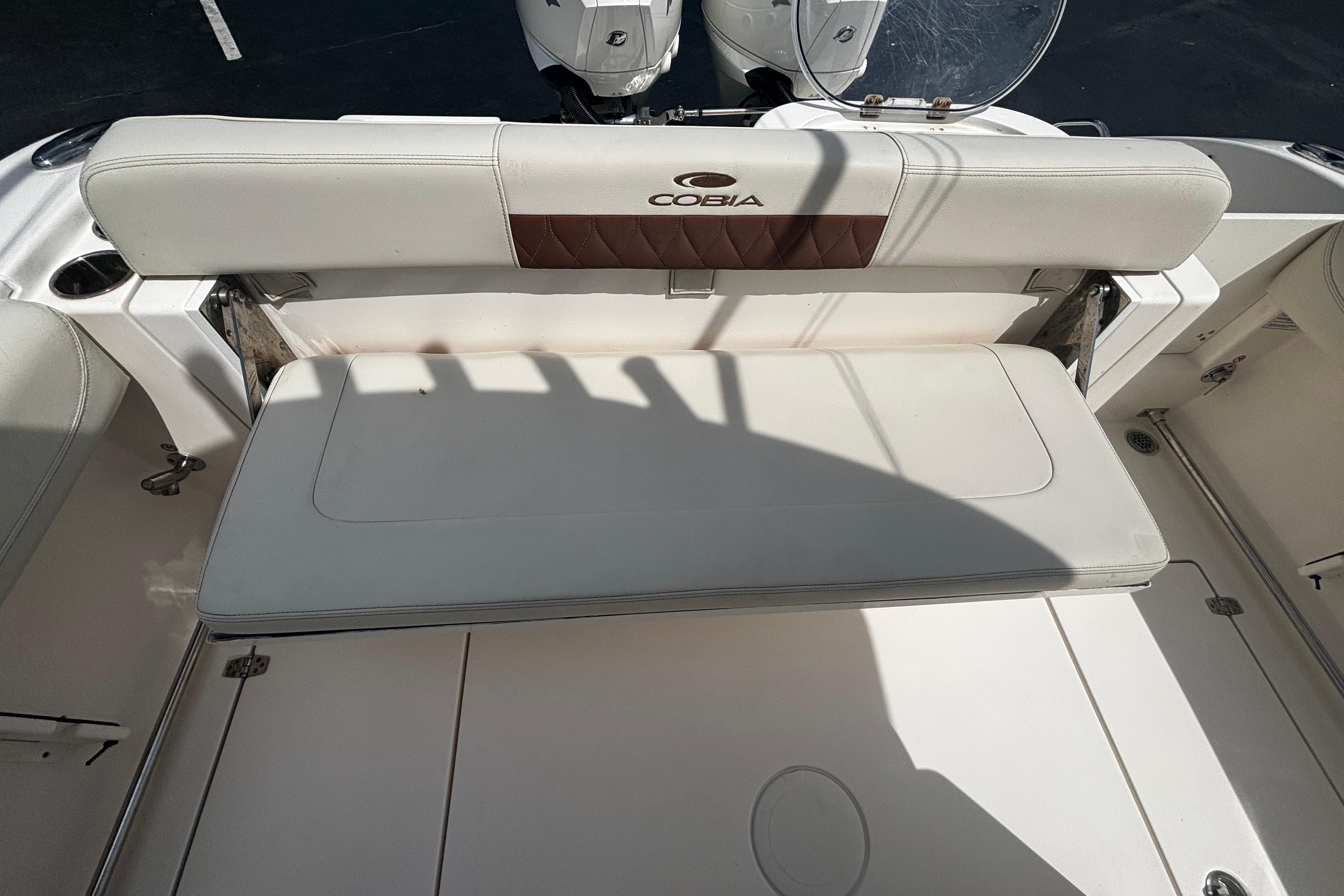 2023 Cobia 262 Center Console boat with white cushioned seating and sleek design.