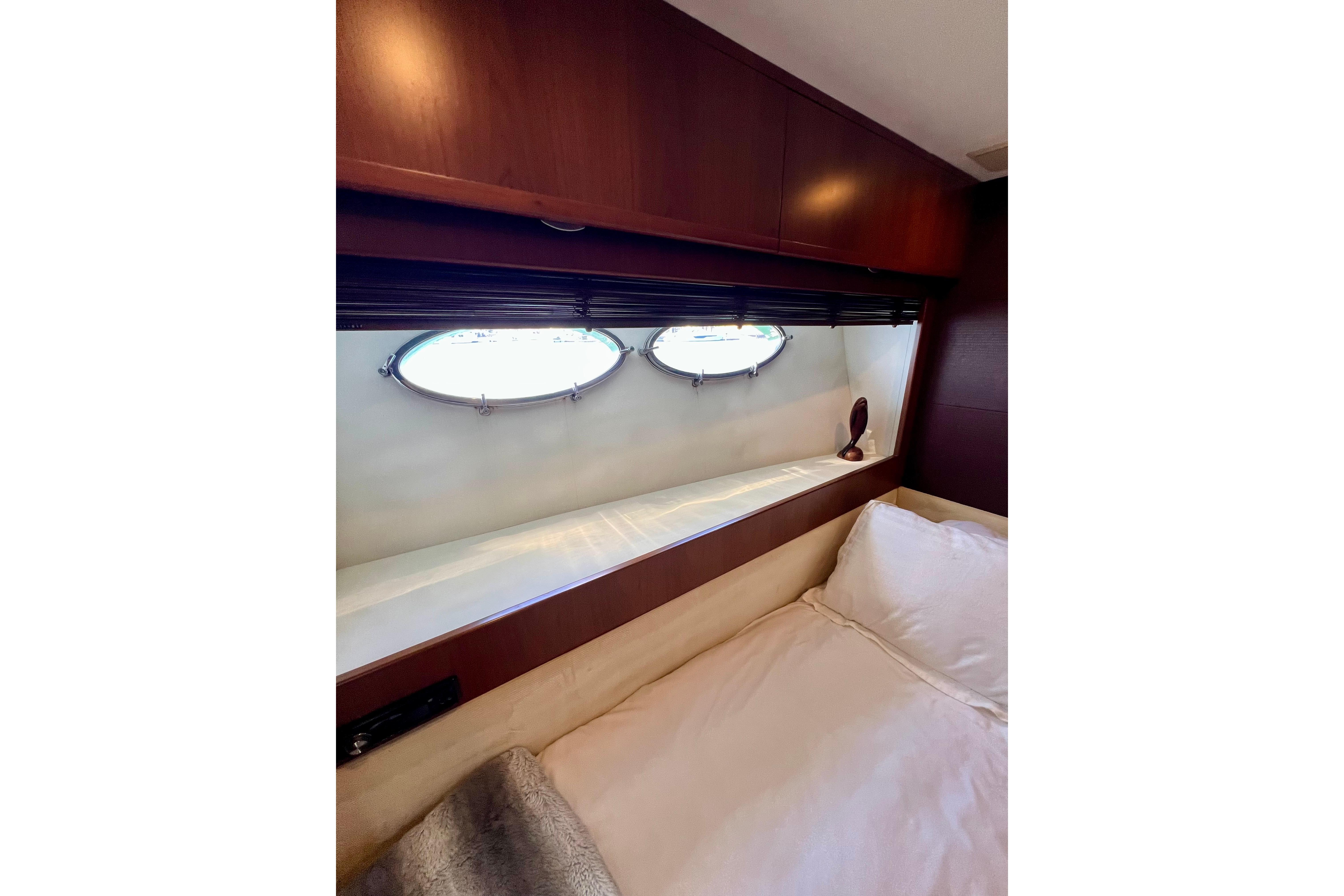 Luxurious cabin interior of 2010 Princess V78 yacht with porthole windows.