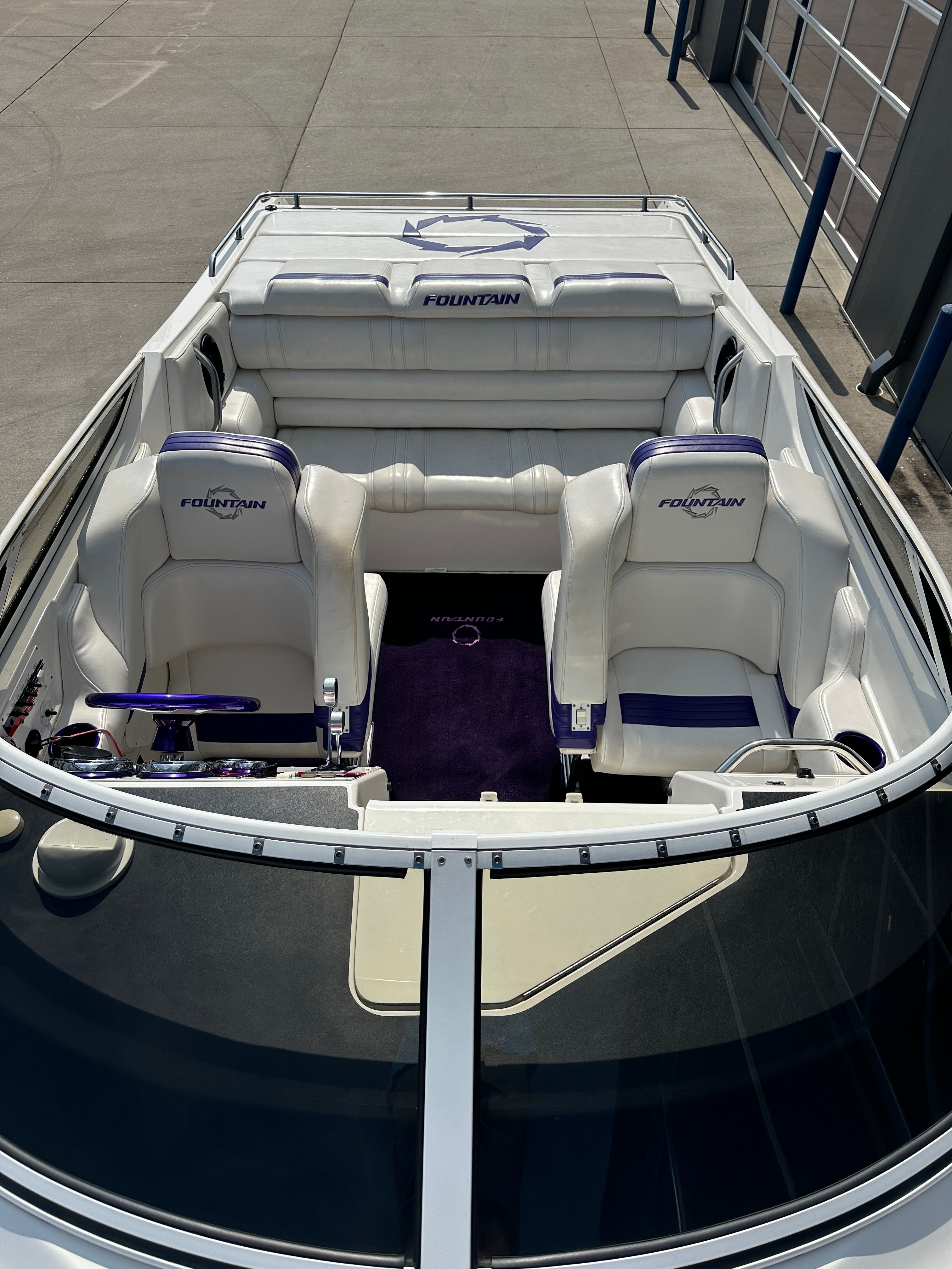 Interior view of a 2006 Fountain 29 Fever boat with white and purple seating.