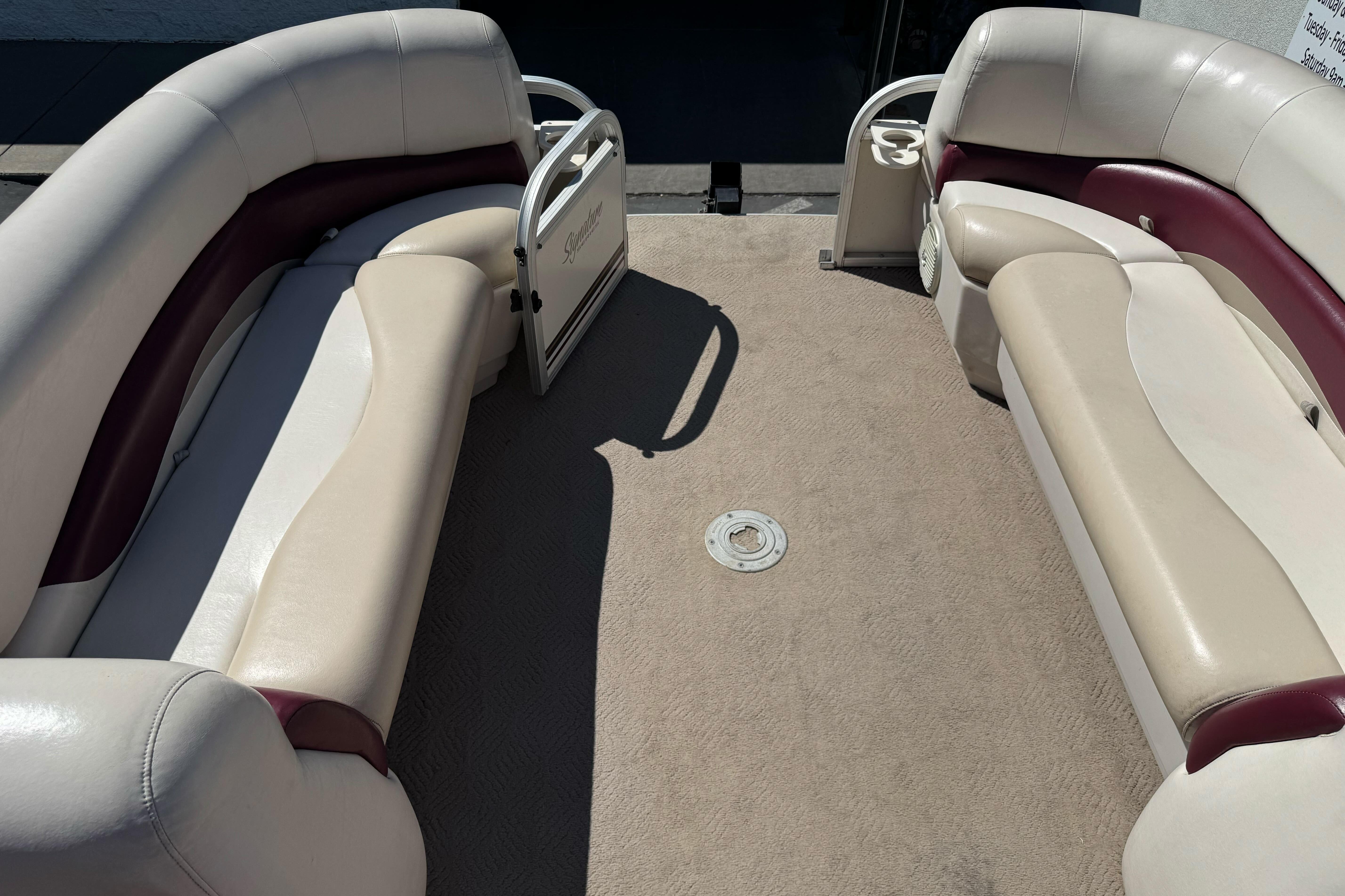 2011 Sun Tracker Party Barge 21 interior with beige and maroon seating, spacious layout.