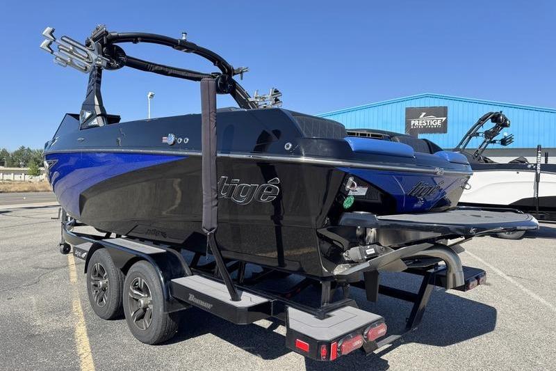 2022 Tigé Z3 boat on trailer, black and blue, parked outdoors.