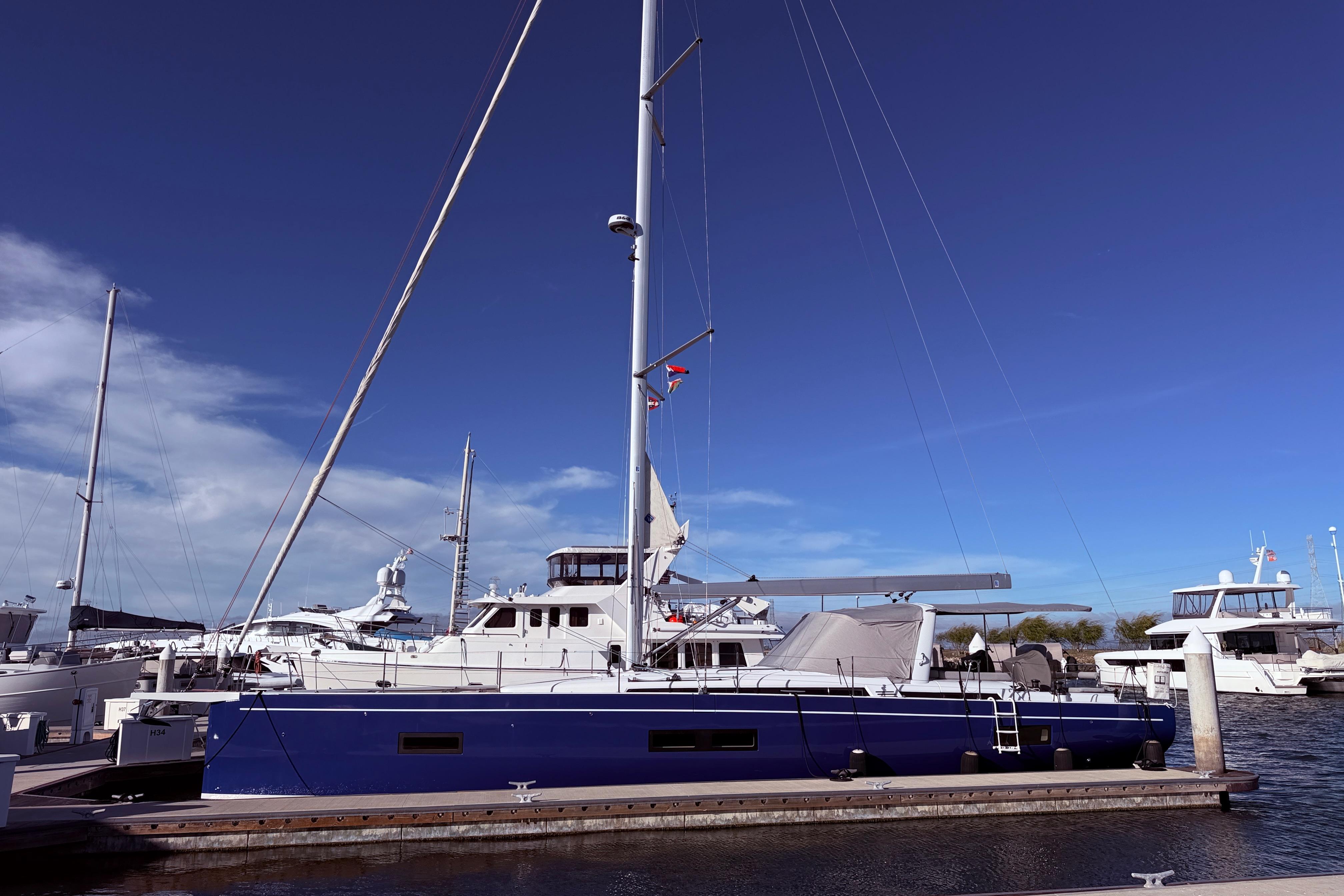 2022 Beneteau Oceanis Yacht 54 docked at marina under clear blue sky.