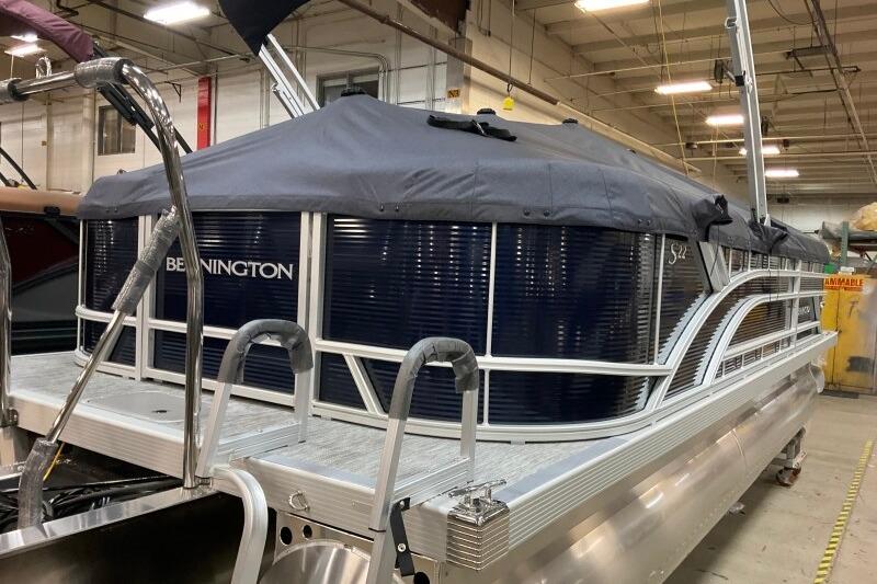 2026 Bennington 22 SSRSF pontoon boat with cover in a warehouse setting.