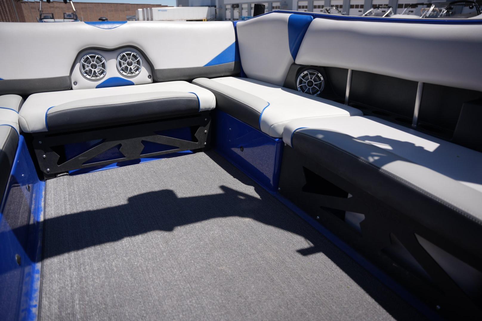 Interior of 2015 Axis A24 boat with blue and gray seating and speakers.